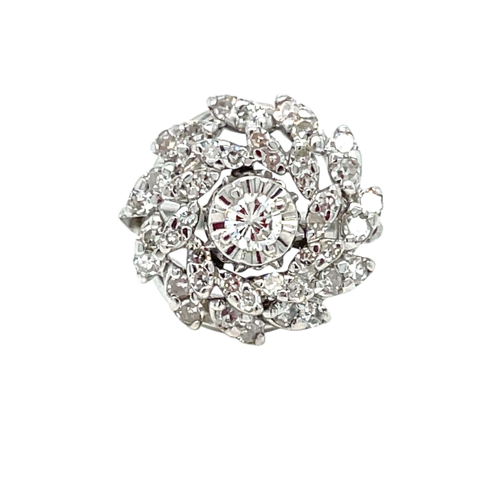 Ein wunderschön gearbeiteter und zeitloser Diamant-Cluster-Ring in 18 Karat Weißgold. 
Der Ring hat einen zentralen Diamanten im Brillantschliff von 0,20 Karat, umgeben von 1,0 Karat runden Diamanten im Brillantschliff mit der Graduierung farblos Vs