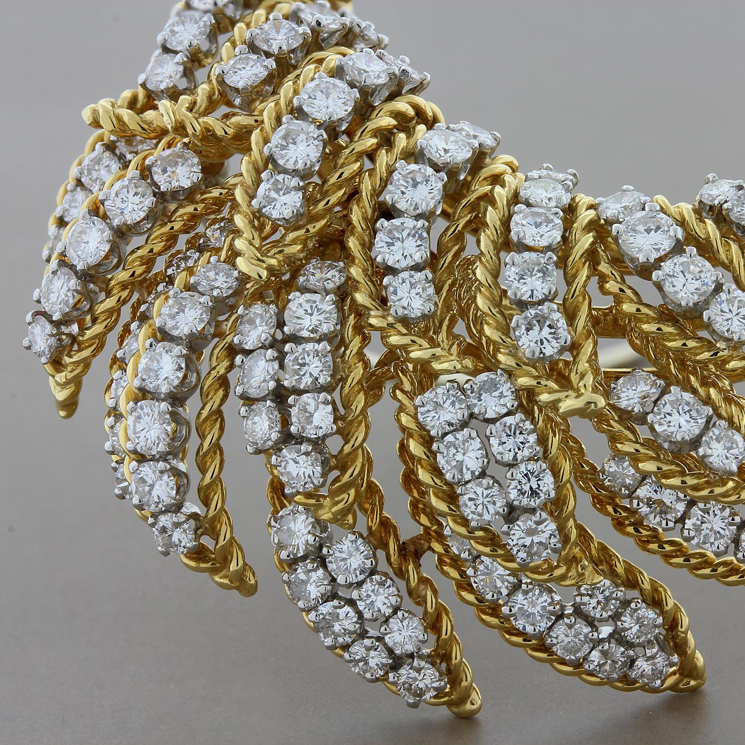 This classic brooch features 6.70 carats of VS quality round cut diamonds set in 18K white gold. The feathers are finely crafted 18K yellow gold with a twist design for added flare. The brooch has a hidden bail so that it may be worn as a pendant
