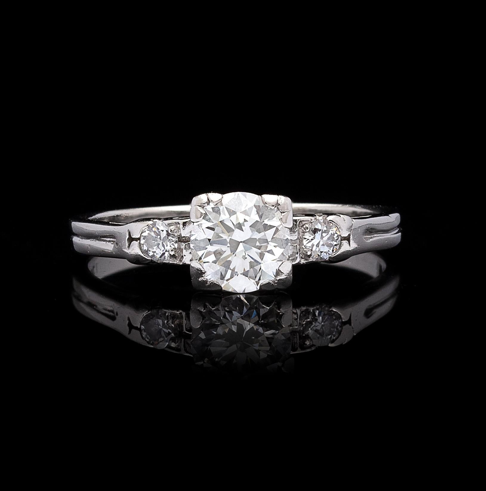 A lovely estate platinum ring, centering a transitional round brilliant-cut diamond weighing an estimated 0.80 carat, accented on either side with two smaller transitional round brilliant-cut diamonds, for an approximate total diamond weight of 0.90