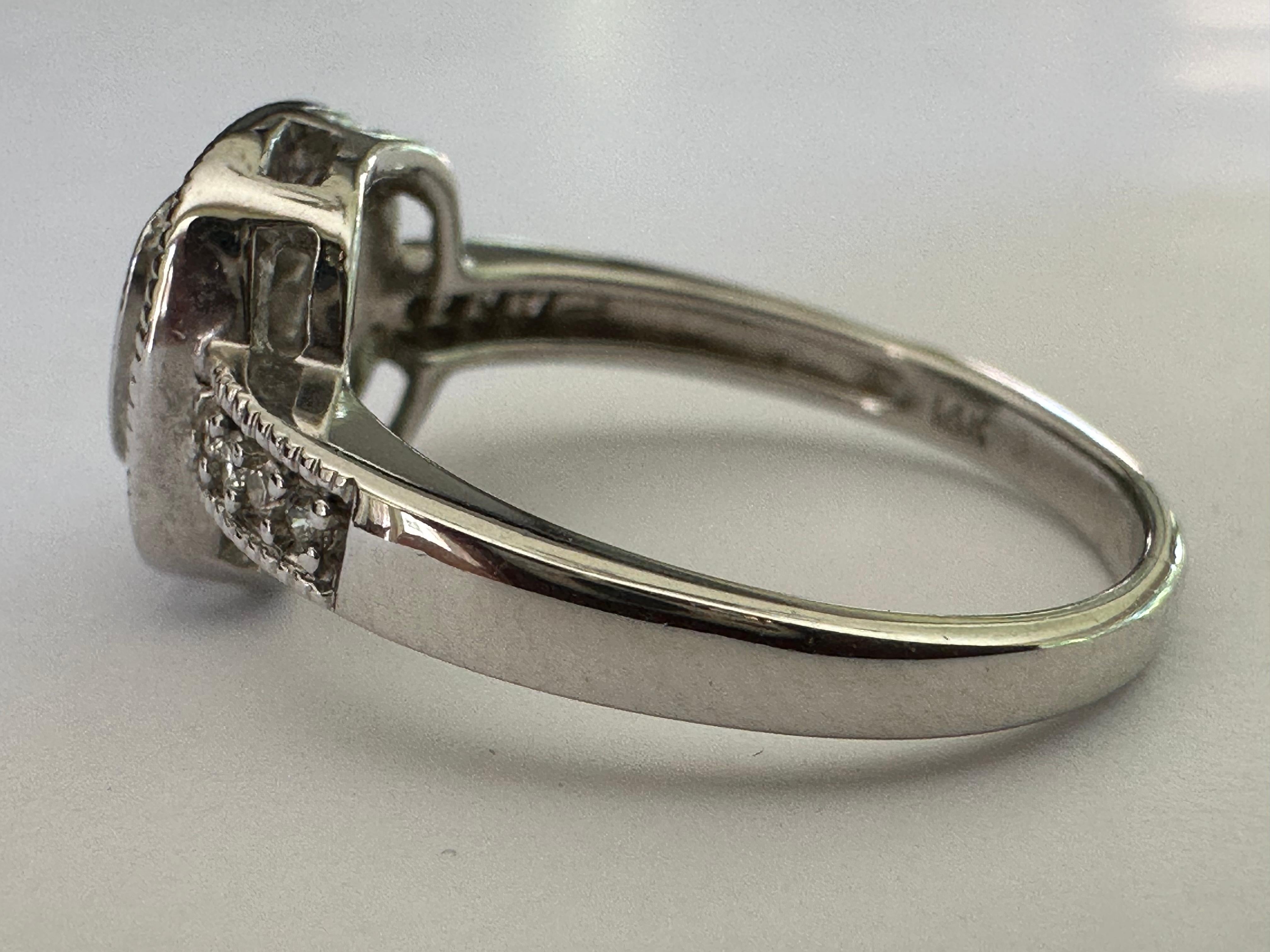 Questo scintillante anello quadruplo è centrato da un'affascinante griglia di nove diamanti taglio princess per un totale di circa 0,18 carati, circondati da un'aureola di sedici diamanti rotondi taglio brillante. Ogni spalla è impreziosita da altri