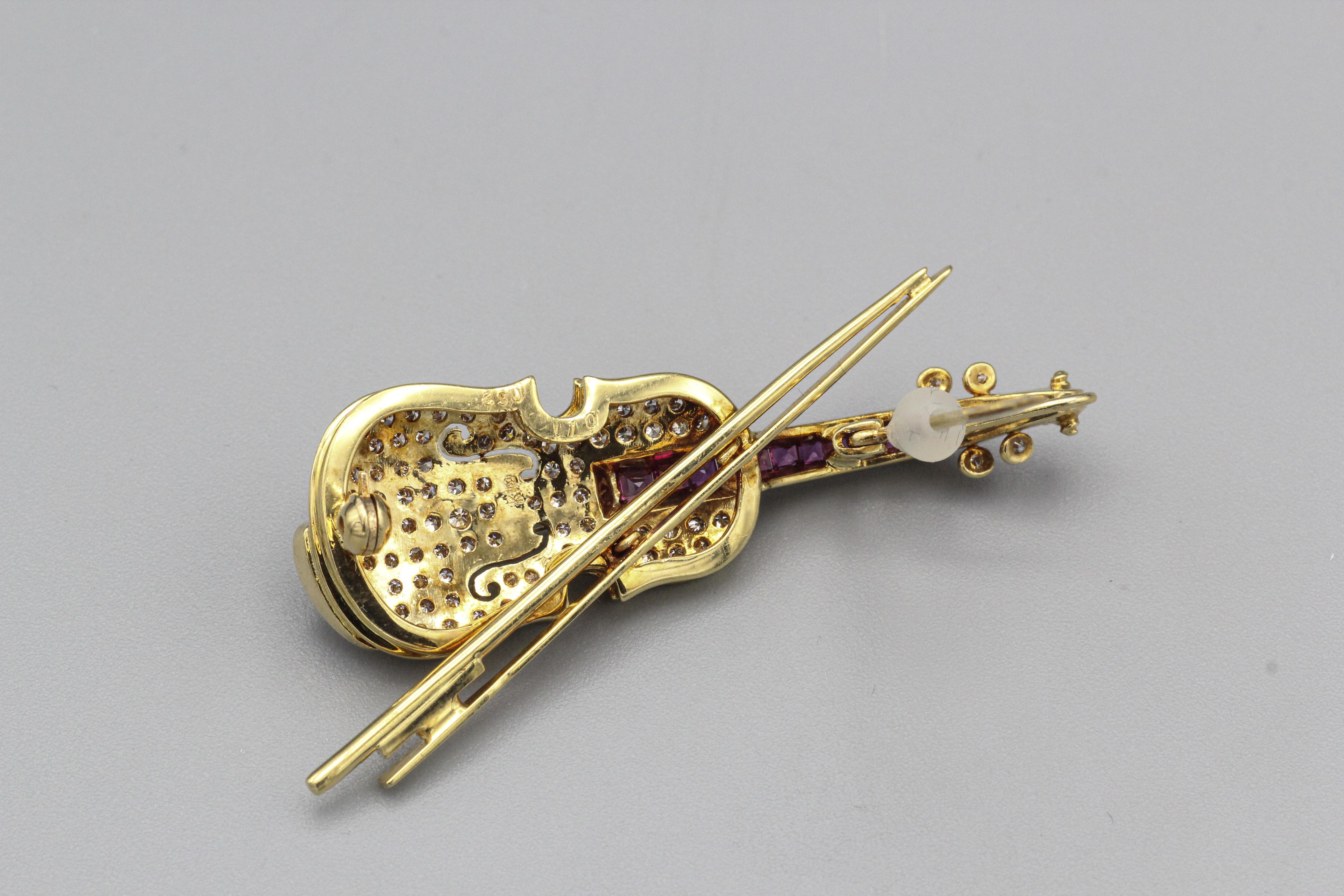 Experience the harmony of craftsmanship and elegance with the Estate Diamond Ruby 18k Yellow Gold Violin Brooch Pin—a unique and captivating piece that pays homage to the world of music. This vintage brooch, with its meticulous detailing and