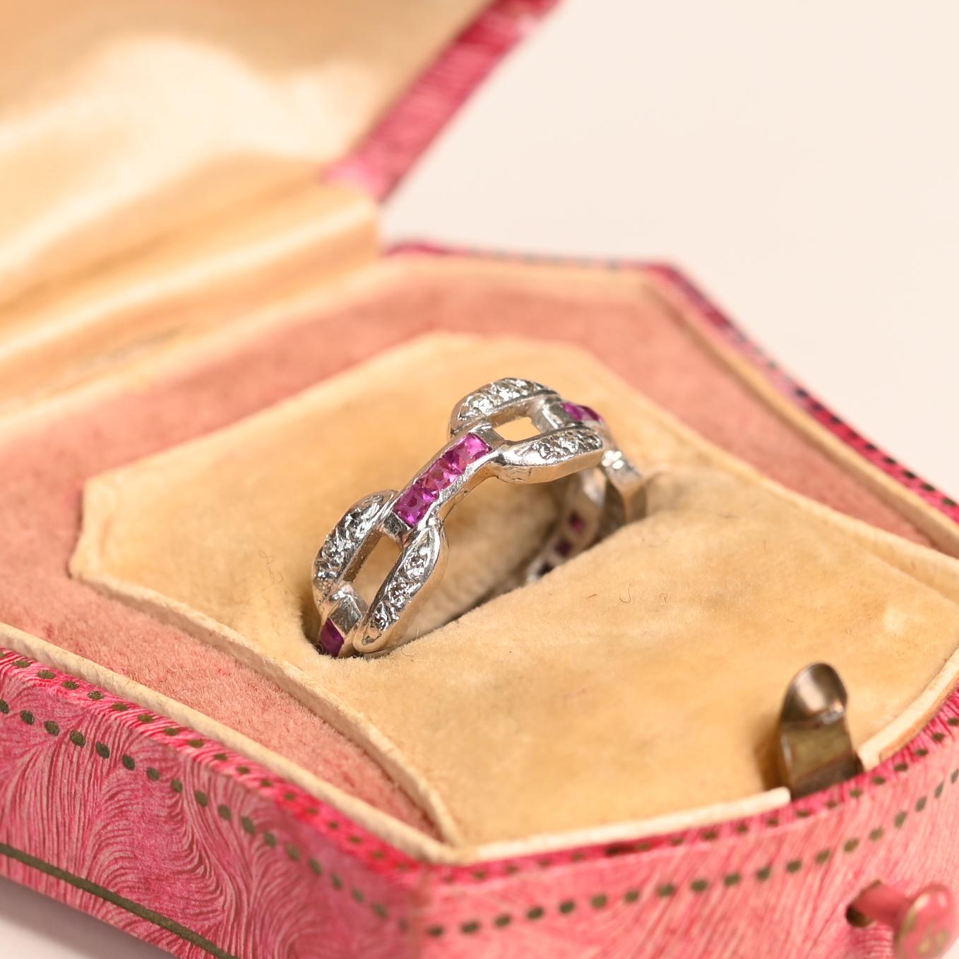 Dieses exquisite und seltene Art-Déco-Band zeigt die zeitlose Eleganz der 1920er Jahre mit einem komplizierten Design aus abwechselnden Diamantgliedern und sorgfältig gefassten natürlichen Rubinen im Kaliberschliff. Die nahtlose Mischung aus