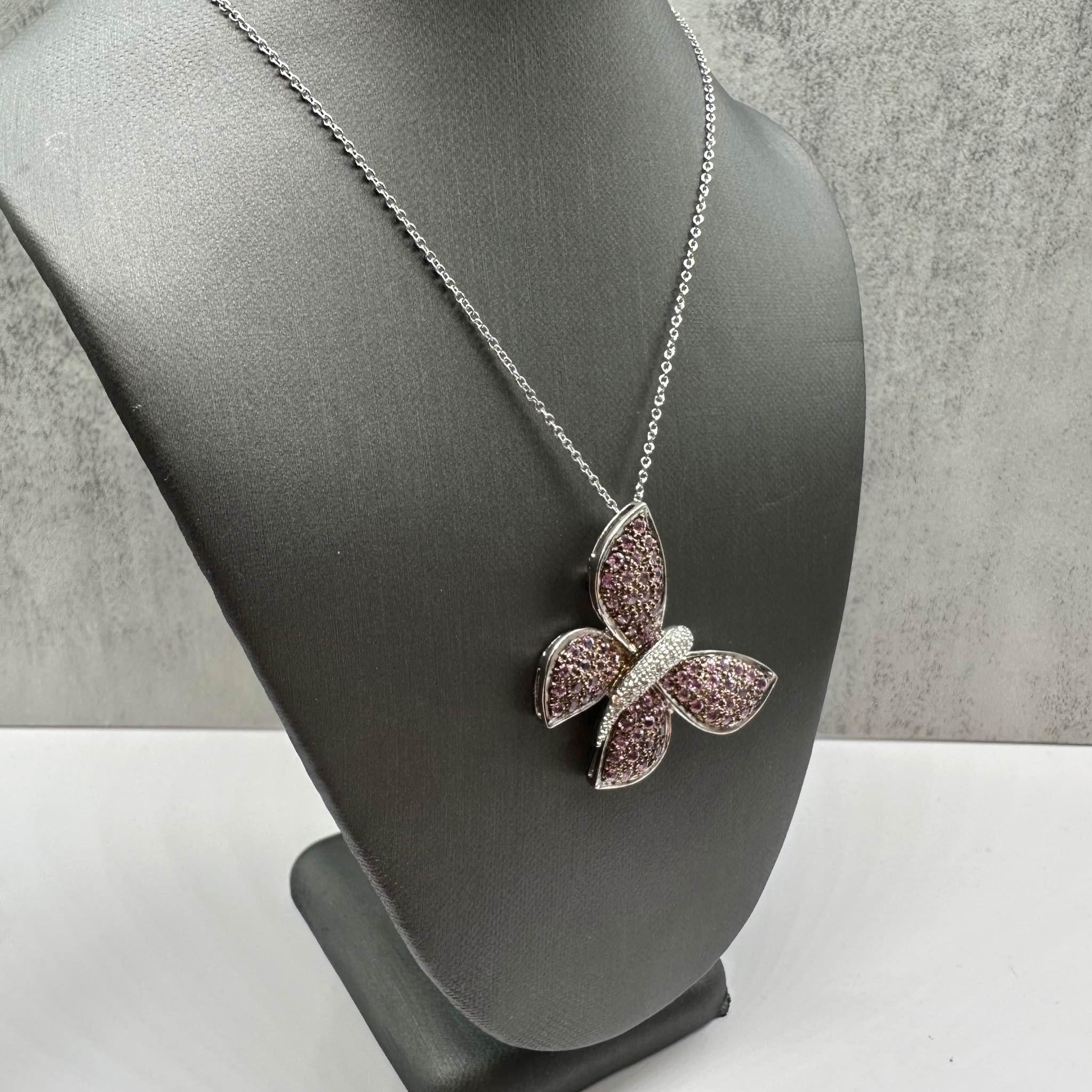 This exquisite Estate Diamond and Sapphire Butterfly Brooch/Necklace features approximately 0.10ctw of natural GH SI2-I1 round diamonds, complemented by approximately 1.5ctw of round pink sapphires for a stunning contrast. The chain is crafted from