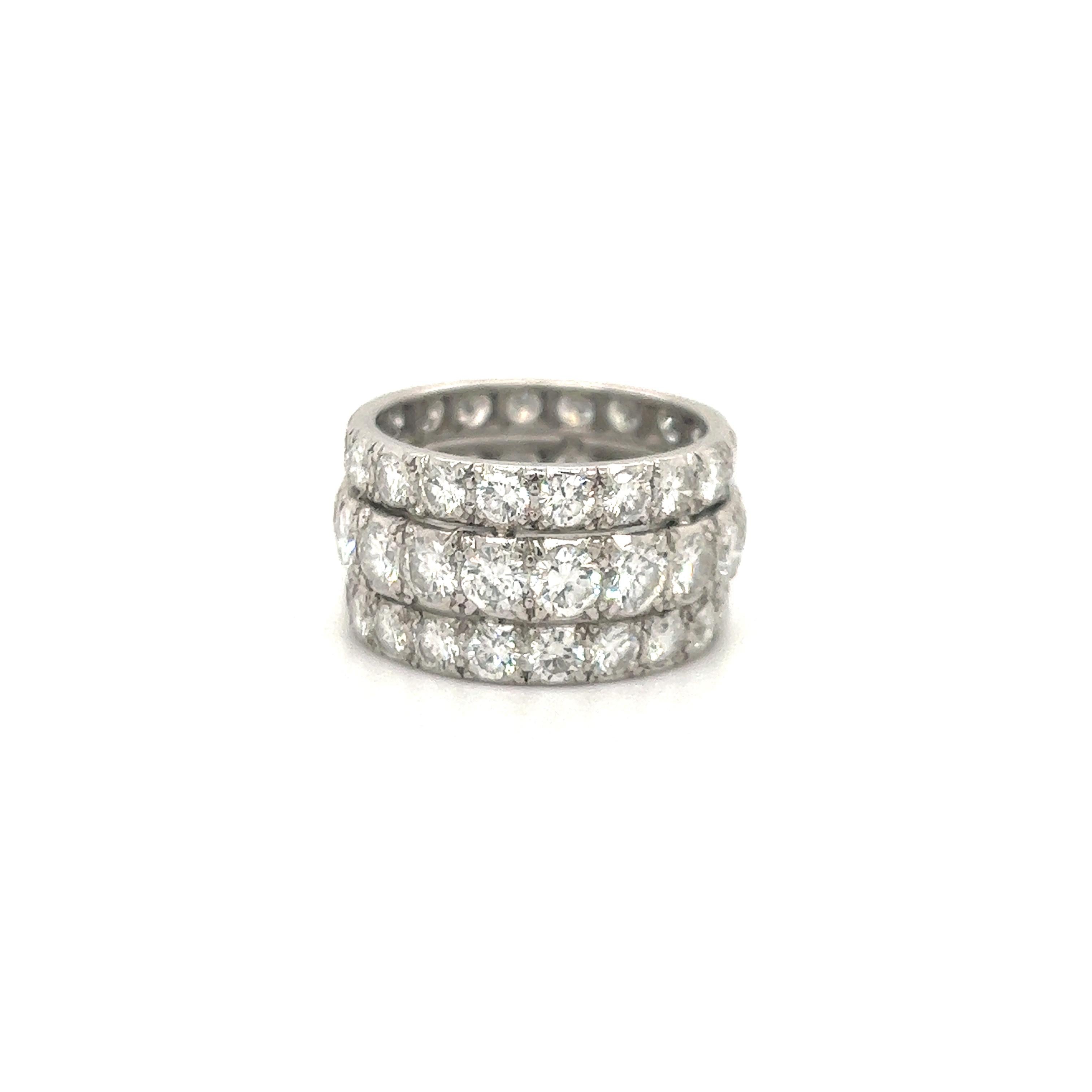 Fantastic design on this wide band estate beauty! This elegant ring is crafted in platinum and set with approximately 6.40 ct. of round brilliant cut earth mined diamonds. The diamonds in the ring are set with an illusion feel as the larger almost