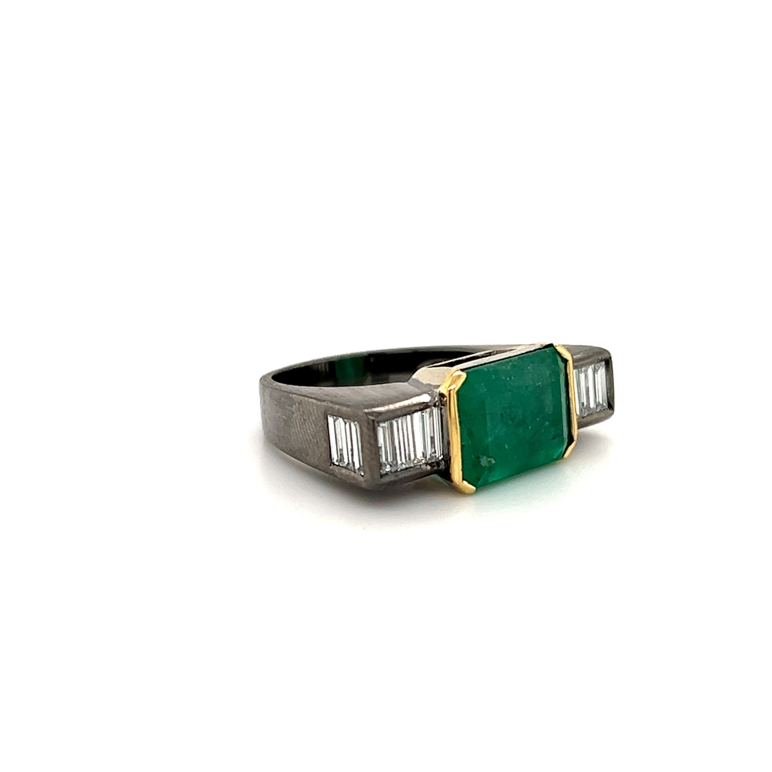 Fantastic design seen on this one of a kind ring. The ring is highlighted with one east/west set emerald gemstone that measures 12 x 8.5 mm and weighs  approximately 4.75 ct.  This ring is truly unique, as sharp edges create this geometric design. 