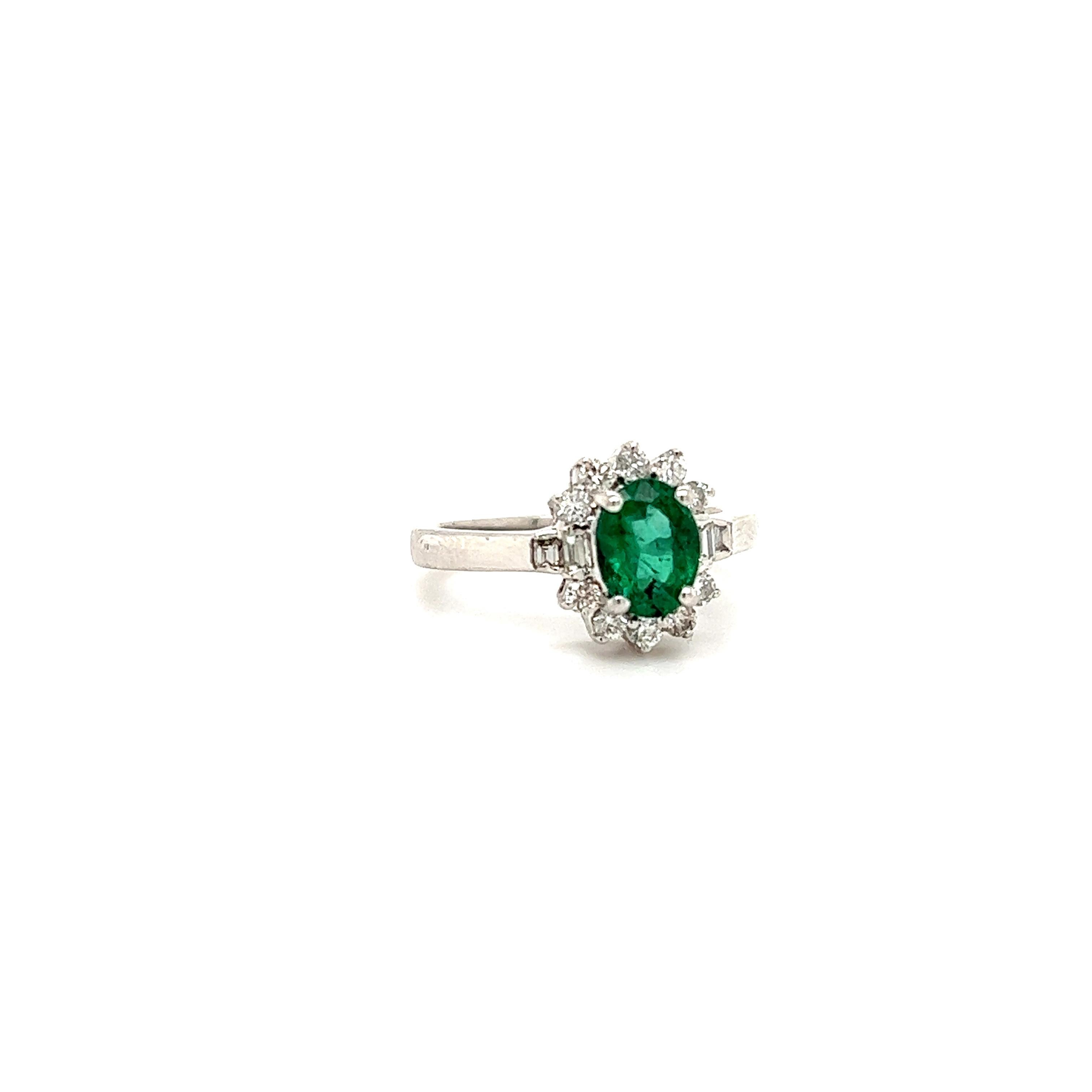 Beautiful ring crafted in 14k white gold. The ring highlights one emerald gemstone in an oval shape. The emerald displays a vivid green color and weighs approximately 1.25 ct. Accenting the emerald are natural round and step cut diamonds. The
