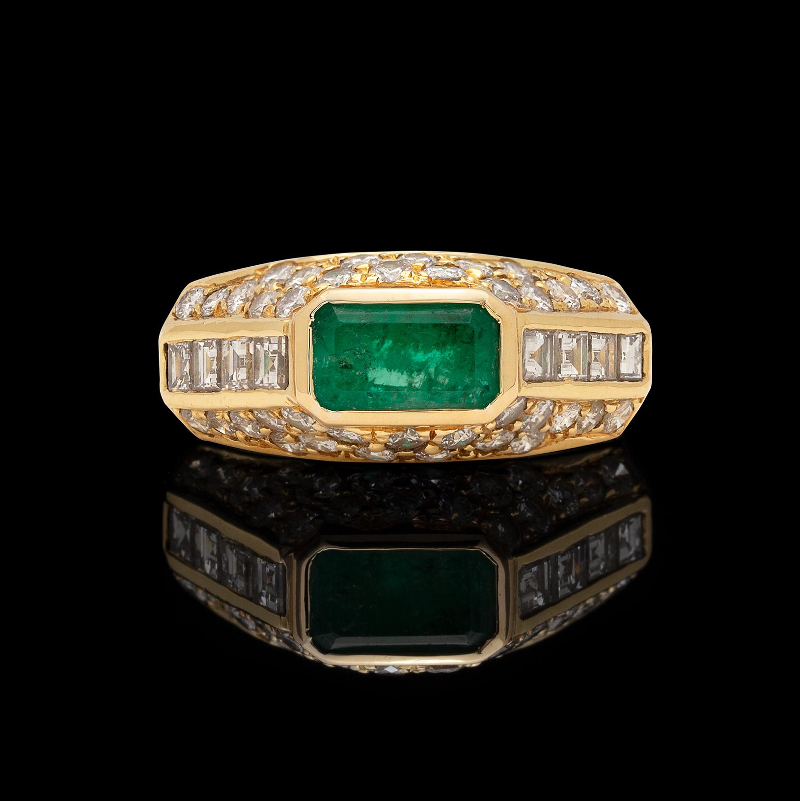 Circa 1980s, this 18k yellow gold ring is still as desirable a design today! Centering a horizontal, bezel-set emerald-cut emerald weighing approximately 2.15 carats, with the angled sides set with 46 square and round brilliant-cut diamonds,