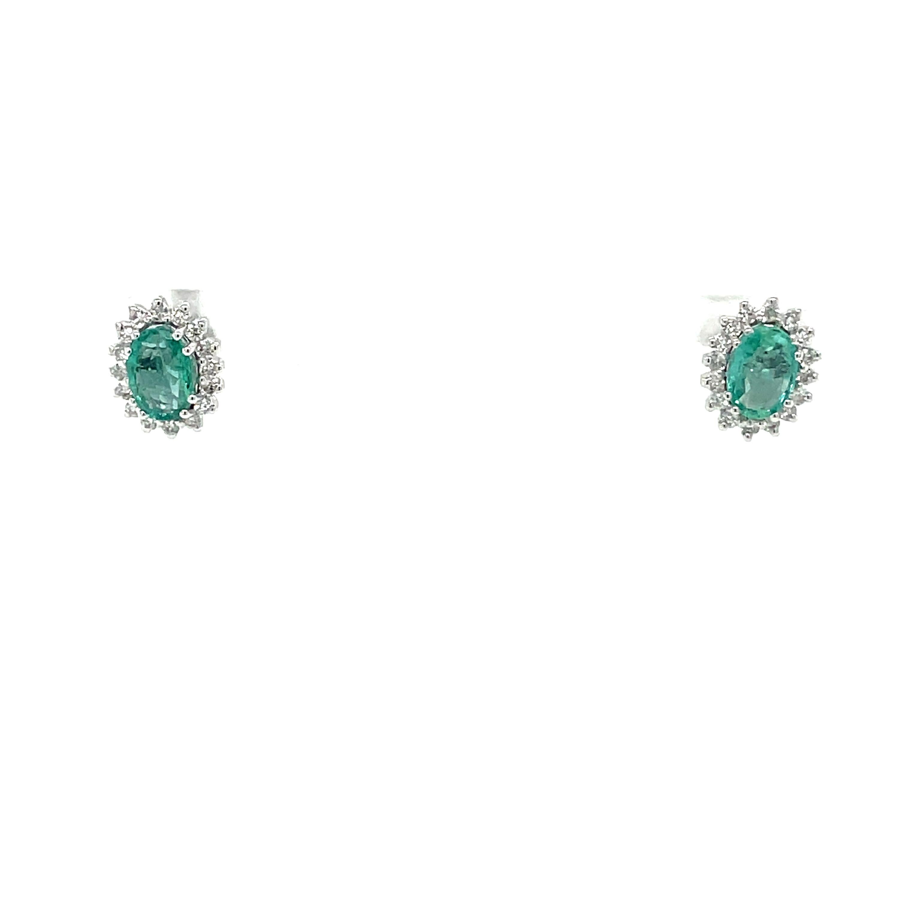 Gorgeous pair of vintage Emerald diamond cluster earrings handcrafted in solid 18k white Gold. 

They are set with Bright Natural Emeralds in the center, total weight 0.80 carat, and surrounded by an halo of colorless sparkling Round Brilliant cut