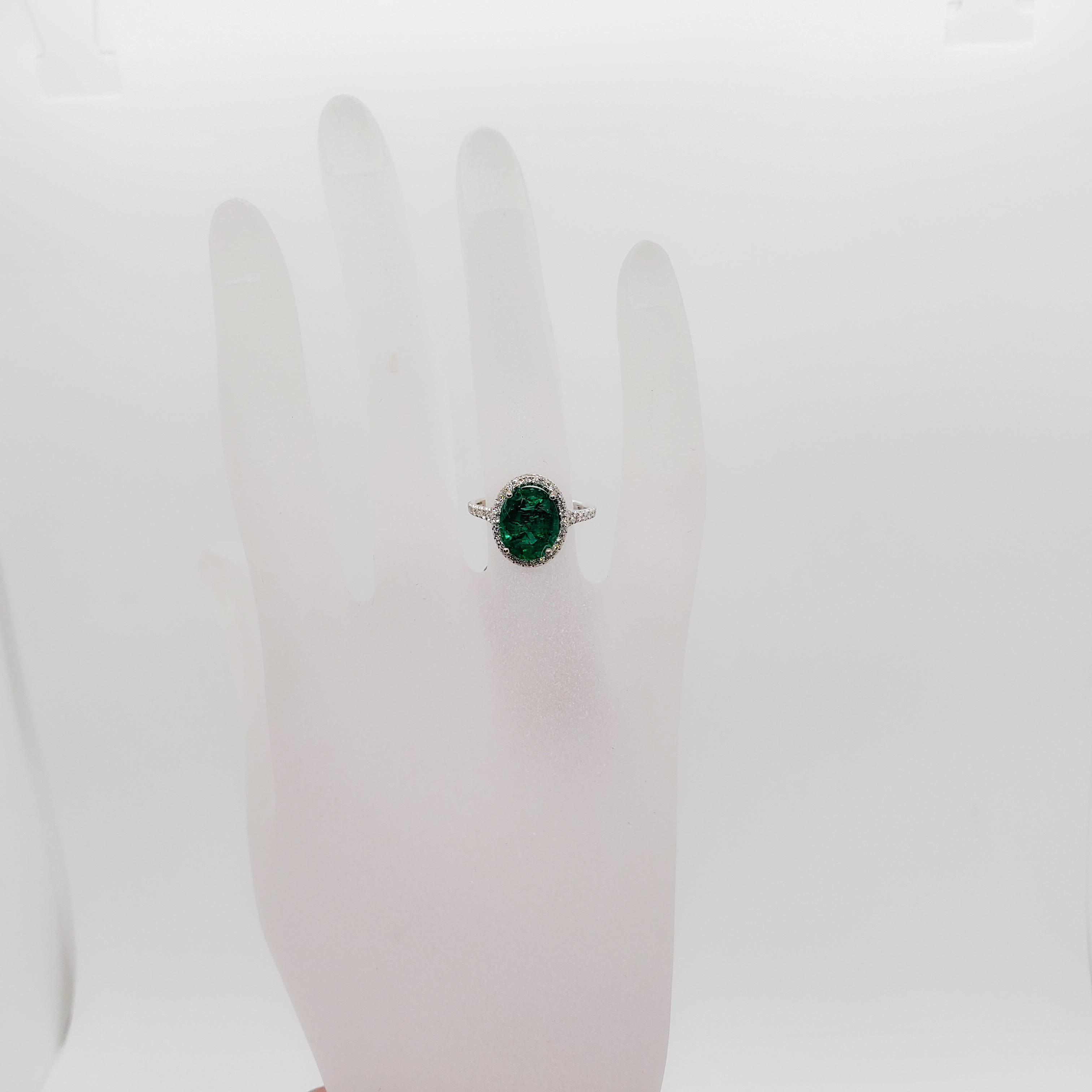 Absolutely stunning perfect green emerald oval weighing 3.42 ct. with 0.36 ct. of white diamond rounds in a handmade 18k white gold mounting. Ring size is 6.25. This ring is perfect for day or night! Excellent condition.
