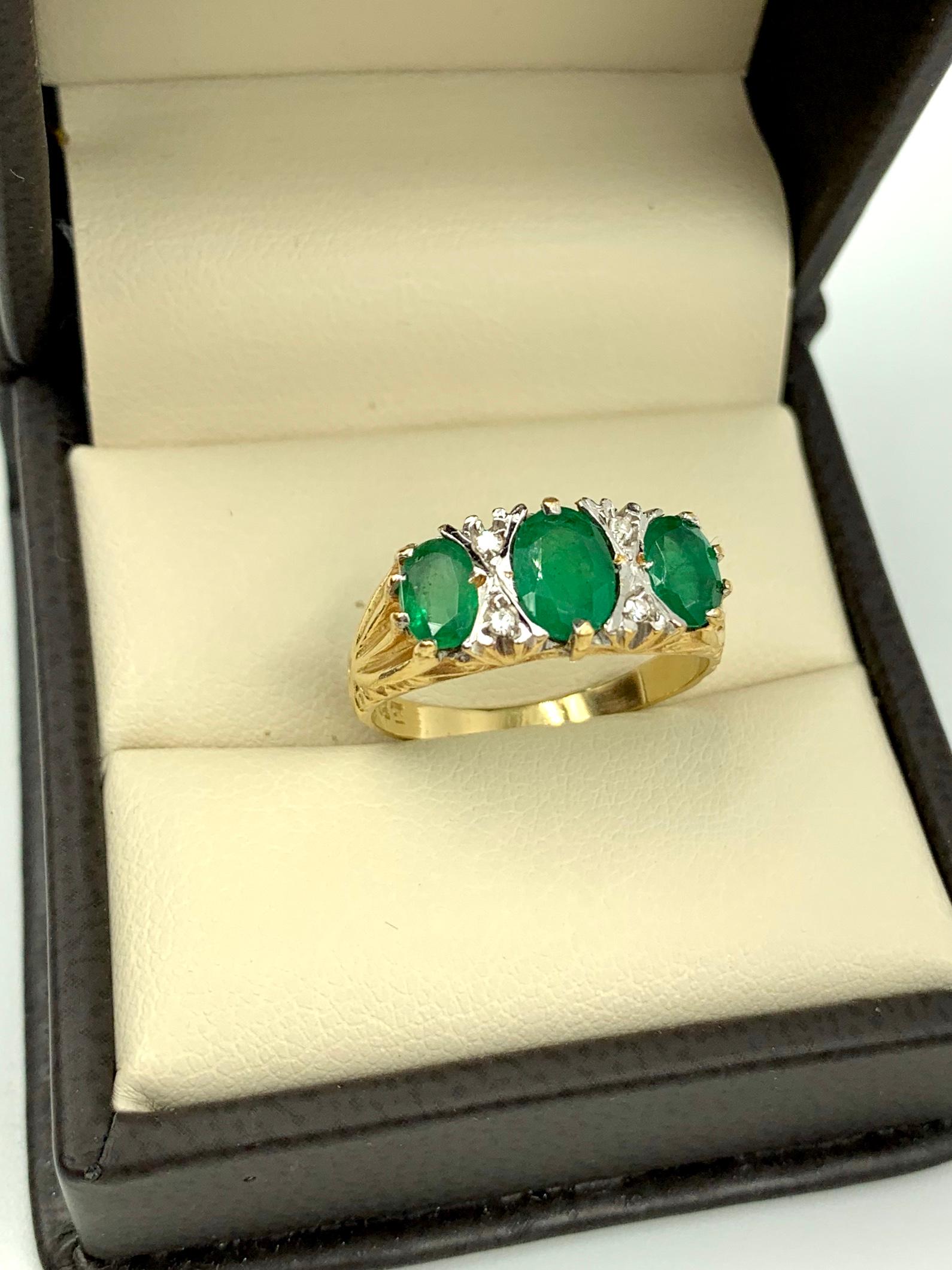 
Center emerald approximately 1 carat, the two flanking emeralds .5 carats each with four diamonds surrounding the center stone in an X formation, the whole forming OXOXO. Lovely gold scroll details at the top and bottom of the setting.
Marks: 18