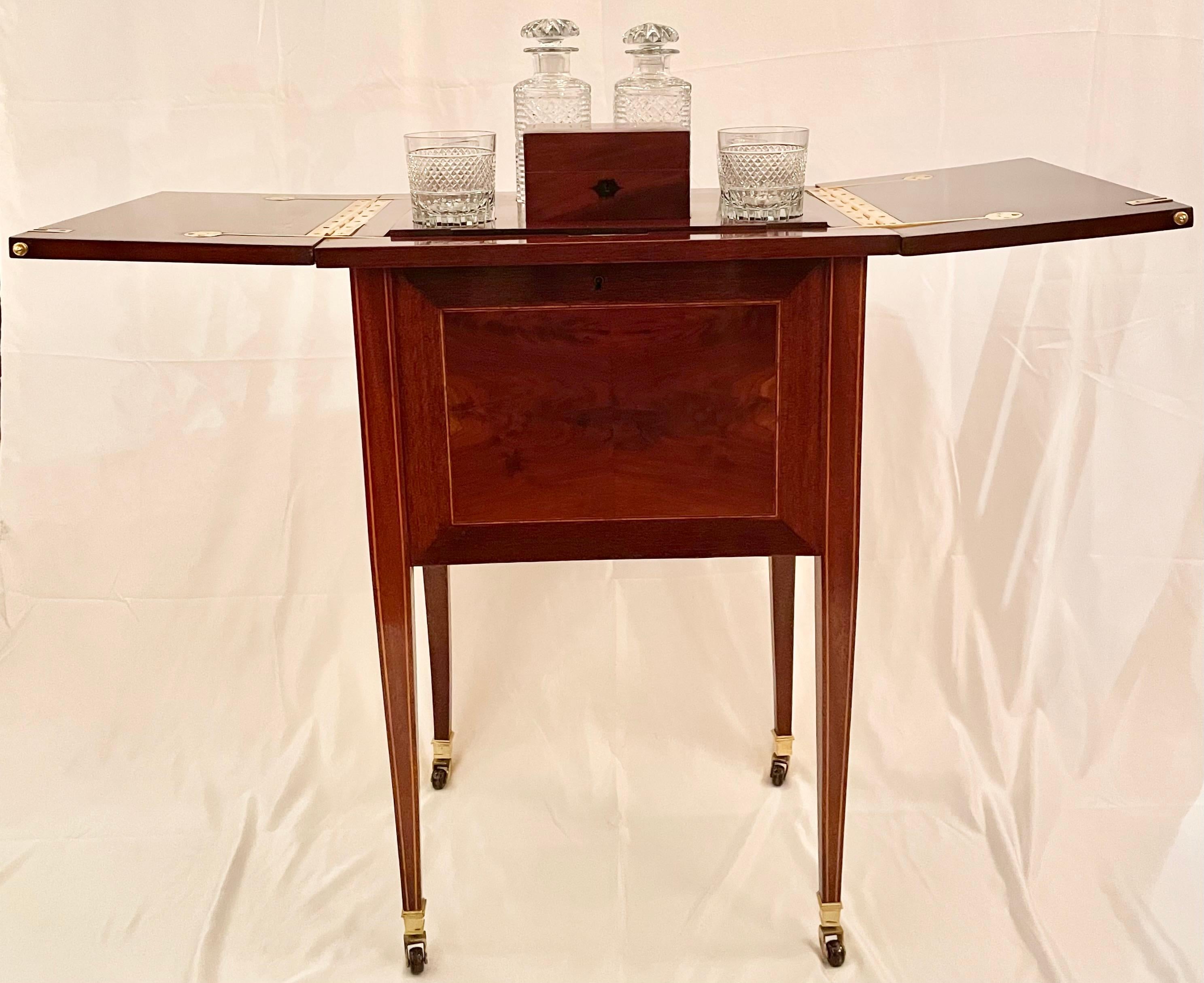 Estate English Mahogany and inlay hidden surprise bar with fitted interior and cut crystal barware on casters, circa 1940's. Includes cut crystal glassware and smoker's box with lock and key. This one is a nice petite size.

Hidden Bar when