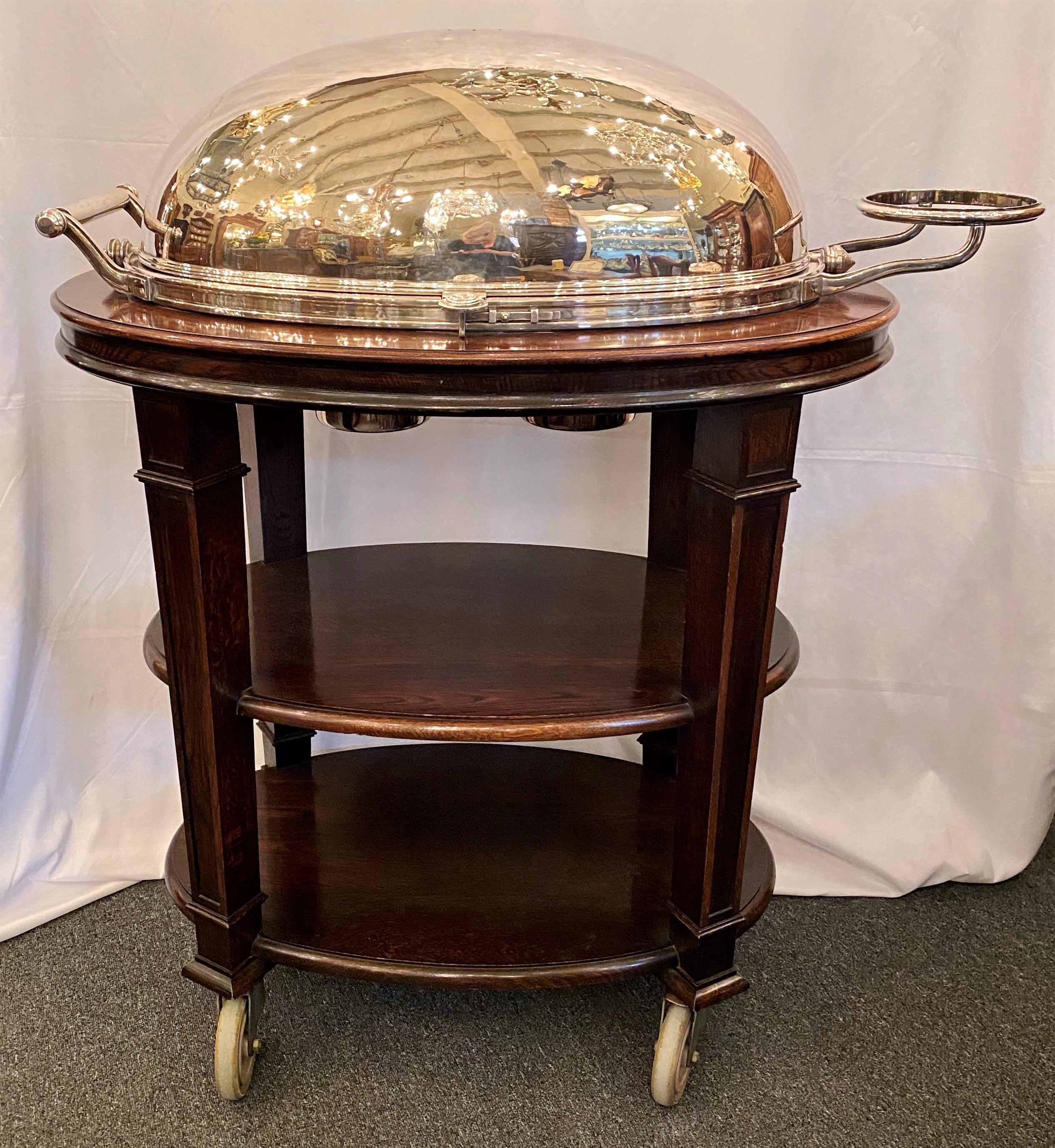 Estate English Sheffield silver plate and mahogany base carving trolley on casters, with warming burners and carving platter, circa 1950.
Measures: 48