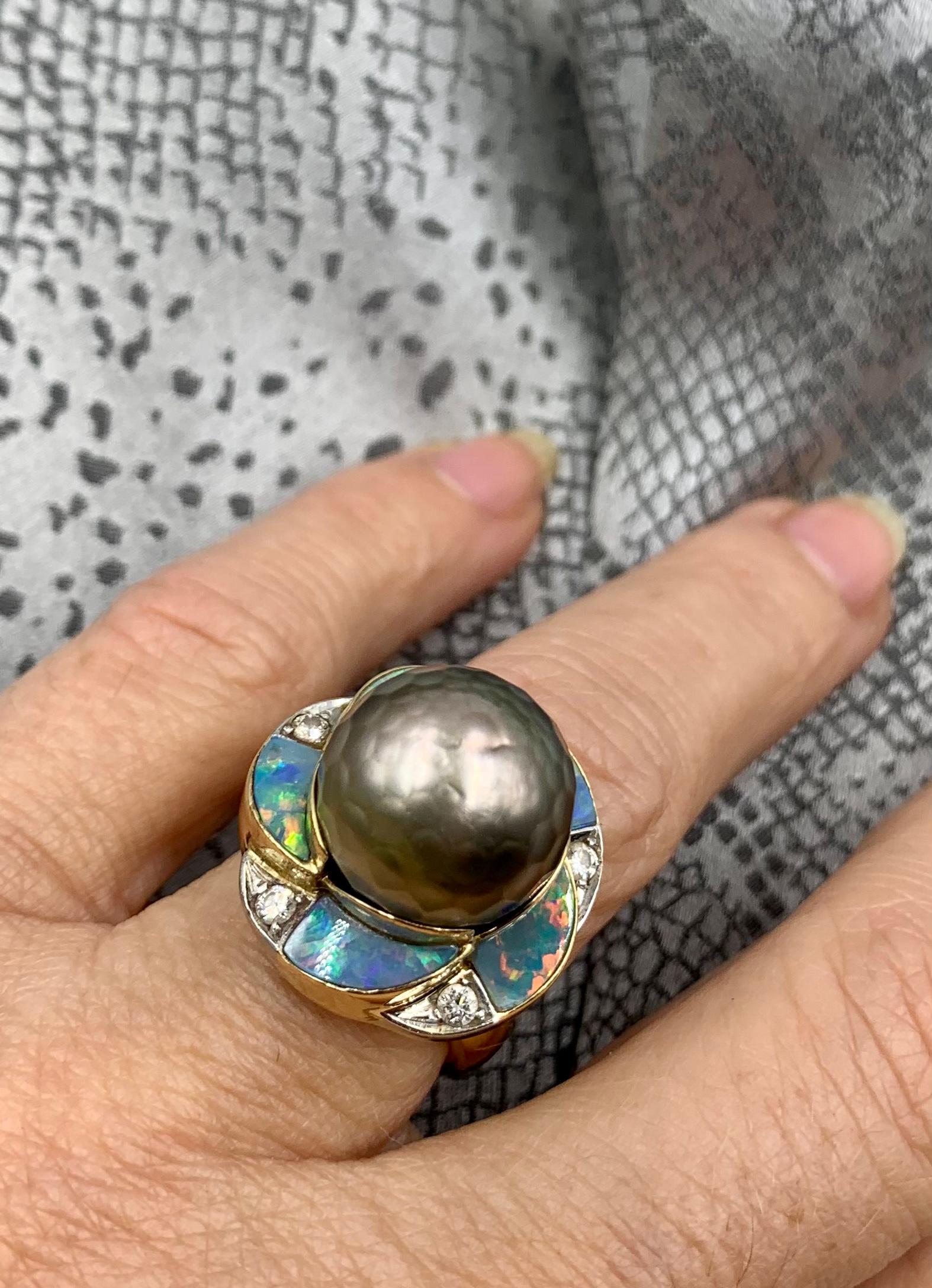 Centering a 13.4mm faceted silvery black freshwater cultured pearl, accented by black opals and diamonds.
Faceted pearls were first created in 1992 by Kazuo Komatsu. Early examples such as the pearl in this ring are quite rare. In recent times,