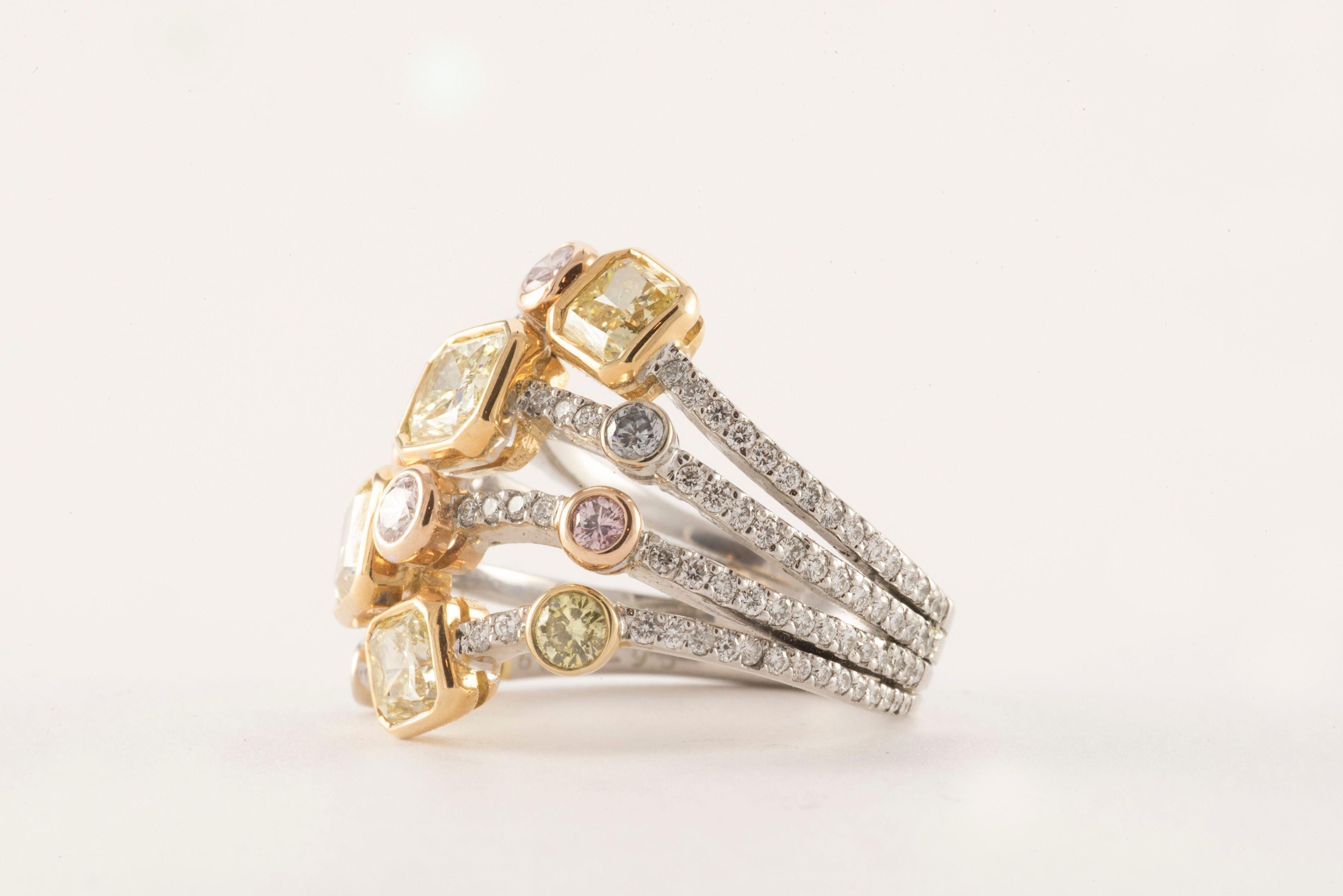 This two-toned magnificent Harem ring crafted from 18kt yellow gold and platinum features a mix of radiant cut and round natural fancy yellow, natural fancy pink, and natural fancy blue diamonds artfully placed atop four stacking bands embellished