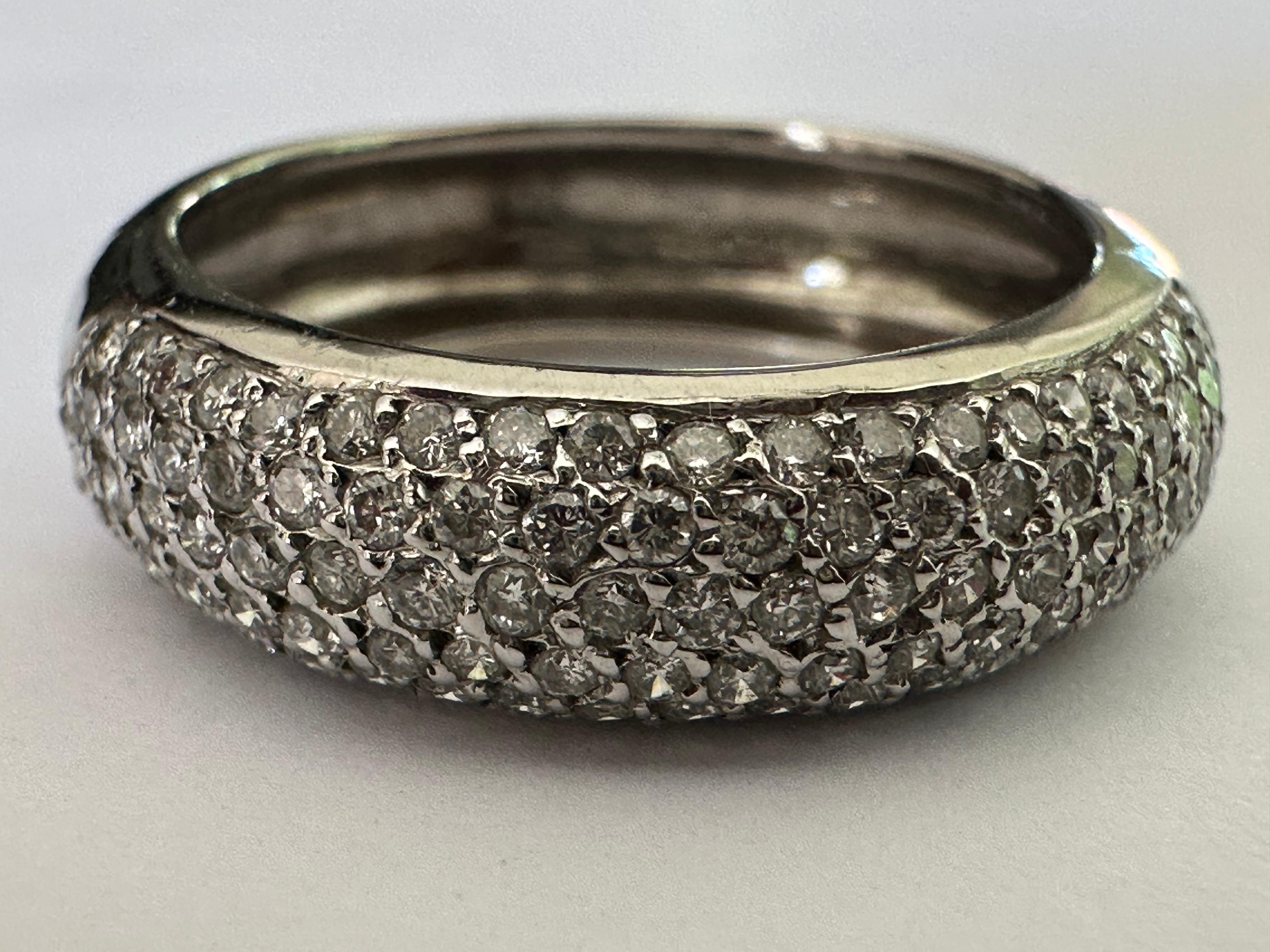 Five rows of pave-set round brilliant-cut diamonds totaling approximately 1.00 carat, F color VS clarity, shimmer across the top of this glittering band crafted in 18K white gold. 

