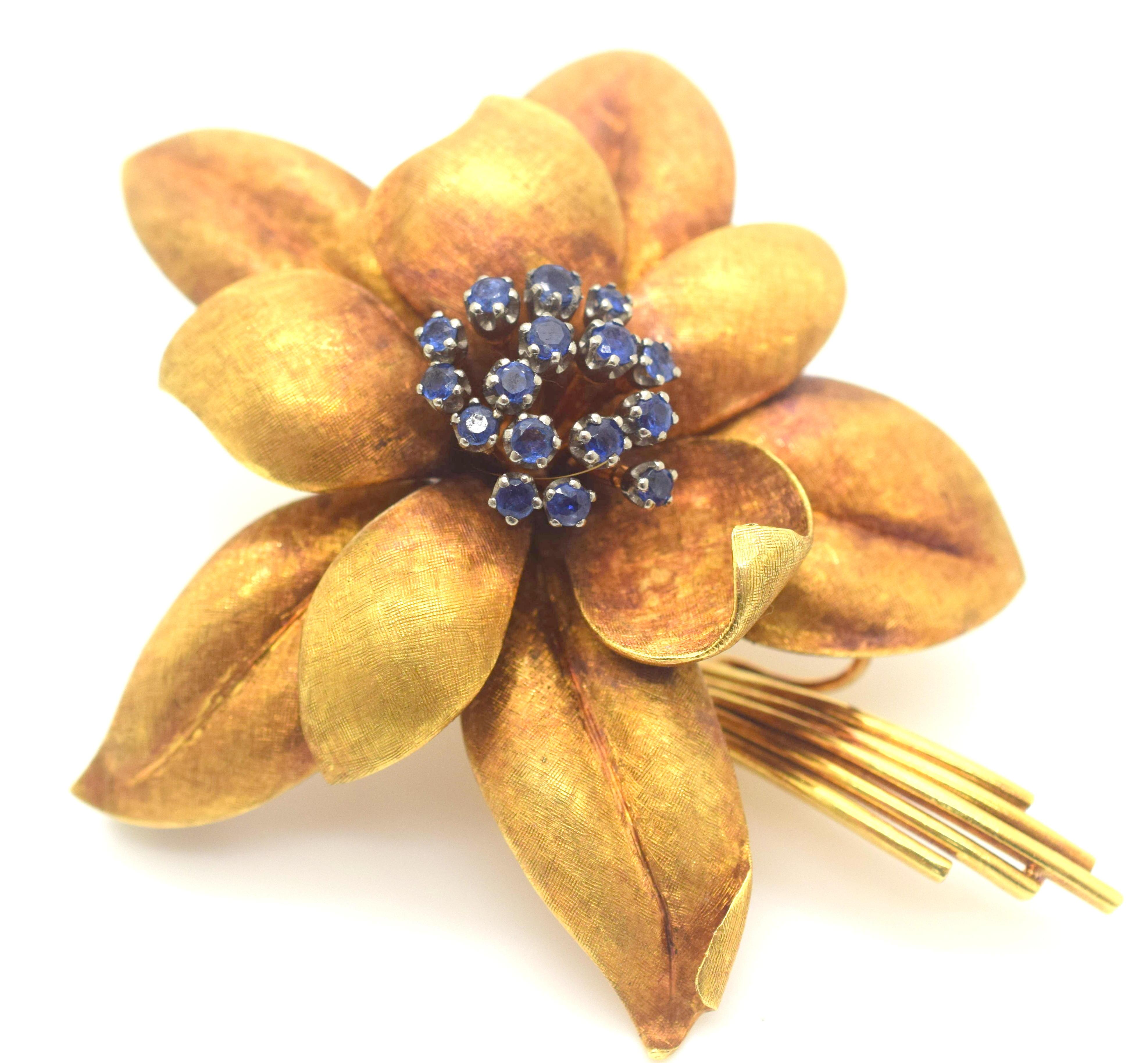 Estate floral brooch crafted in 18k yellow gold. This brooch is a timeless piece of jewelry that is coming back into style. The craftsmanship is exceptional where the leaves of the flower show a textured finish appearing life like. The brooch was