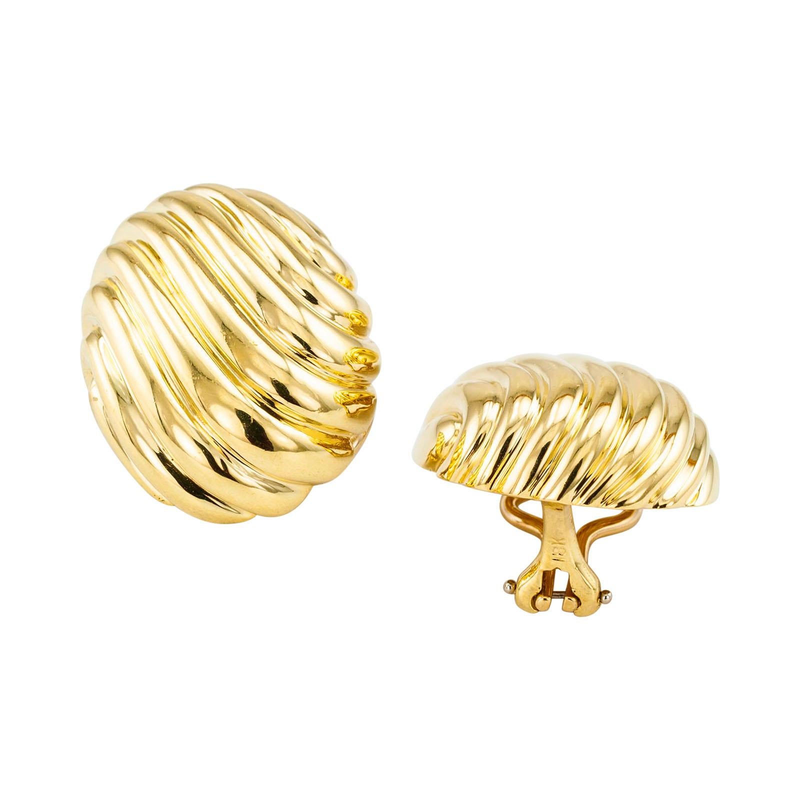 Fluted yellow gold ear clips.

DETAILS:
Button style fluted yellow gold omega clip back earrings circa 1970.
METAL: 18-karat yellow gold.
MEASUREMENTS: approximately 1 1/16” (2.7 cm) by 13/16” (2.1 cm), 22.7 grams.
CONDITION: high magnification