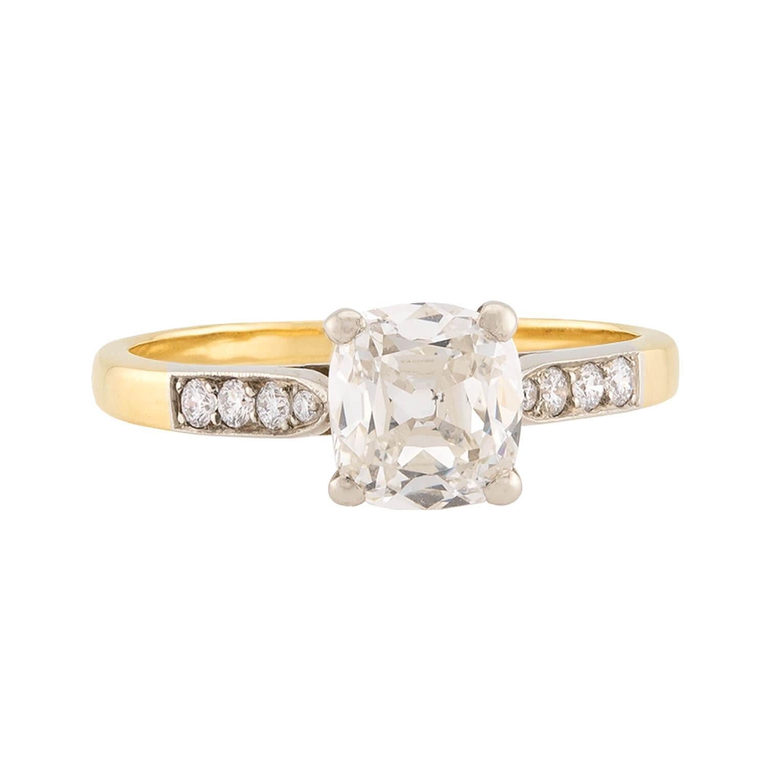 Un fantastico anello di fidanzamento con diamante! Realizzato in oro giallo vibrante da 18 carati, questo anello presenta un diamante taglio cuscino da 1,23 carati. La pietra ha un colore M e una purezza SI1. Ogni spalla dell'anello è impreziosita