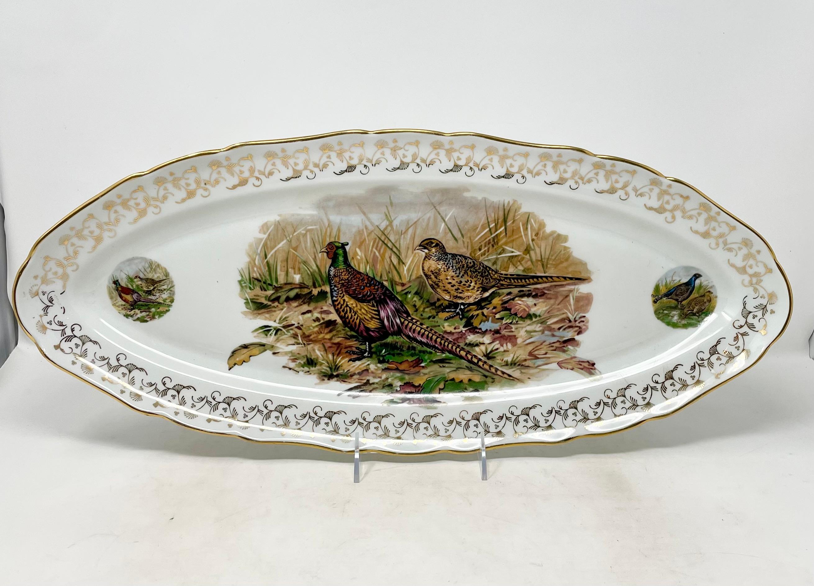 Set de 11 oiseaux de chasse en porcelaine de Limoges, 10 assiettes et 1 plat.

Plateau :
1 1/2