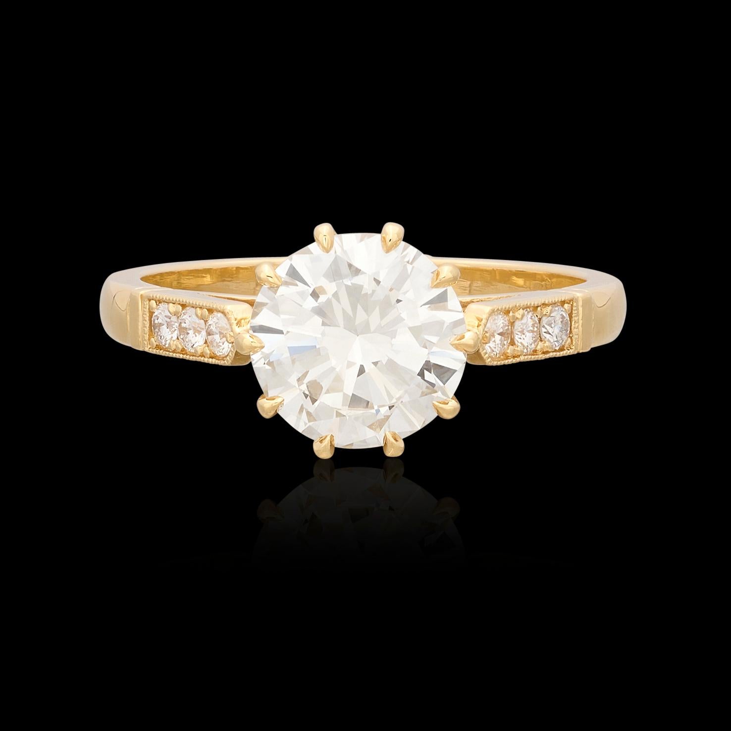 A timeless design with a modern twist and superior sparkle. The 18k yellow gold ring features a 1.84 carat round brilliant-cut diamond graded by the GIA as J/VVS1, set in 10 prongs for a unique look. The shoulders are set with six additional