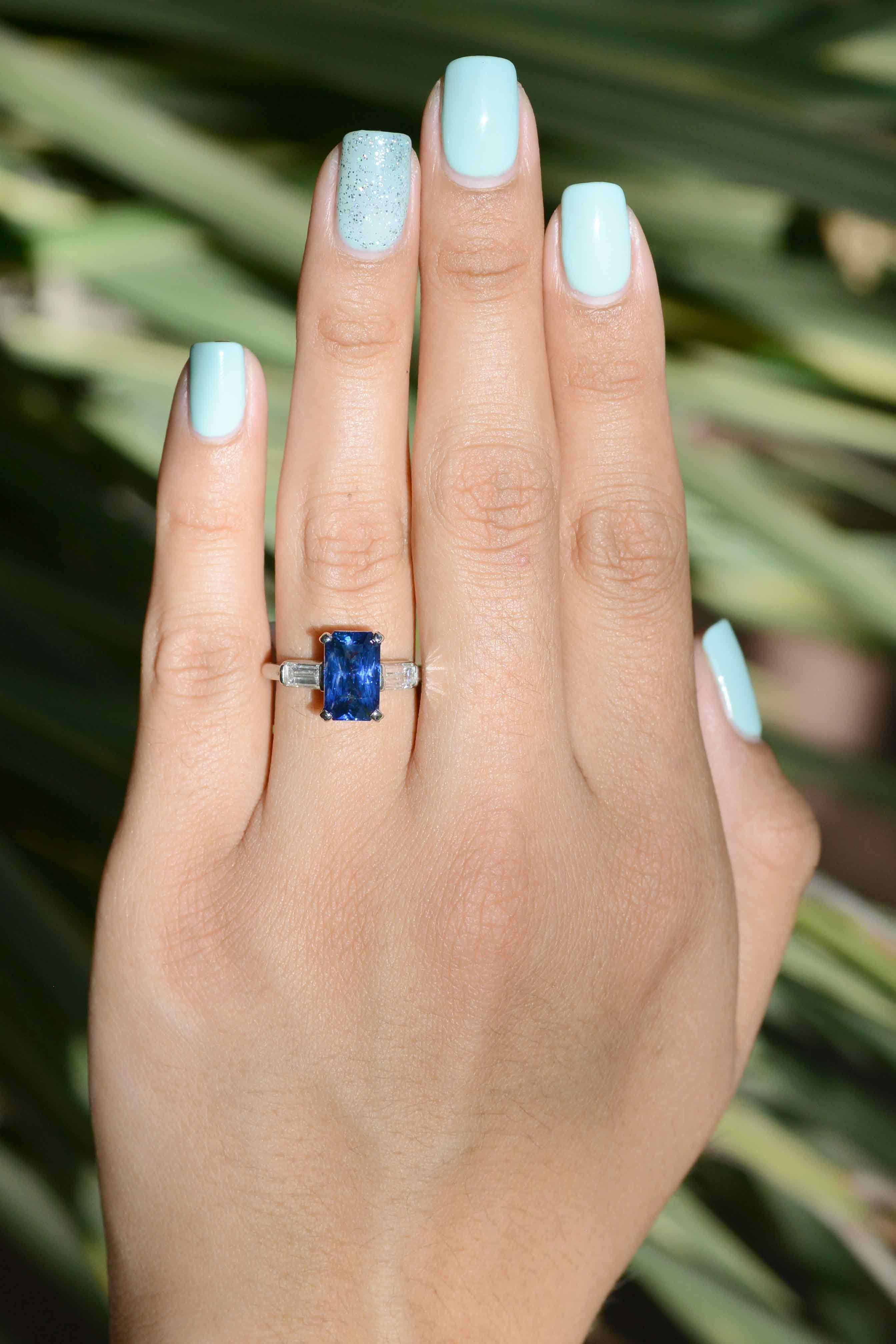 This emerald cut 4.15 carat blue sapphire and diamond engagement ring embodies the reason why we love estate jewelry. The diamond baguettes subtly accentuate the marvelous, captivating blue this sapphire displays.  GIA certified as natural sapphire.
