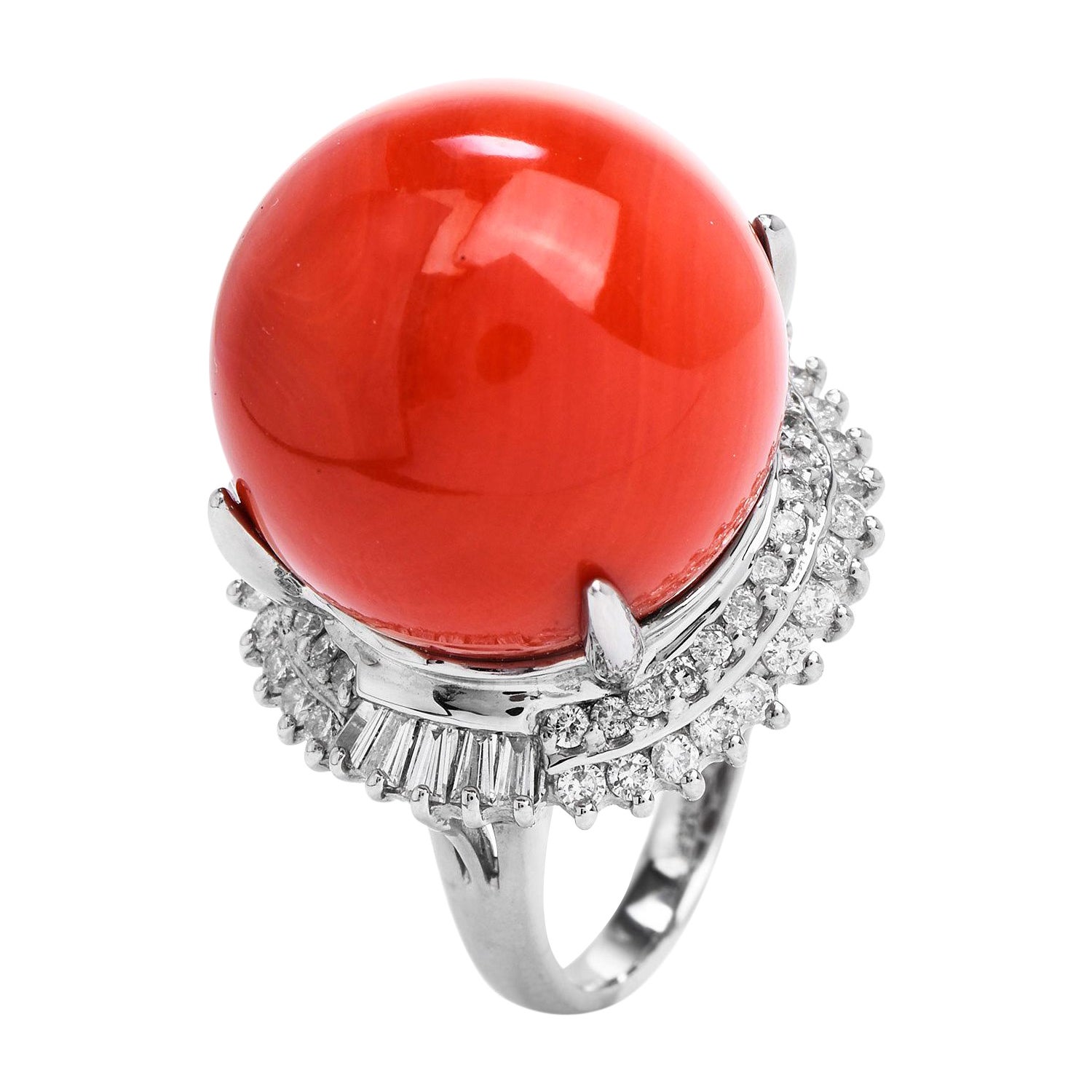 This high-quality natural red coral diamond ring is crafted in solid platinum, weighing 18.5 grams and measuring 20mm x 16mm high. Displaying one prominent four-claws prong-set natural coral of salmon-red color measuring 18 mm. Enhanced by a