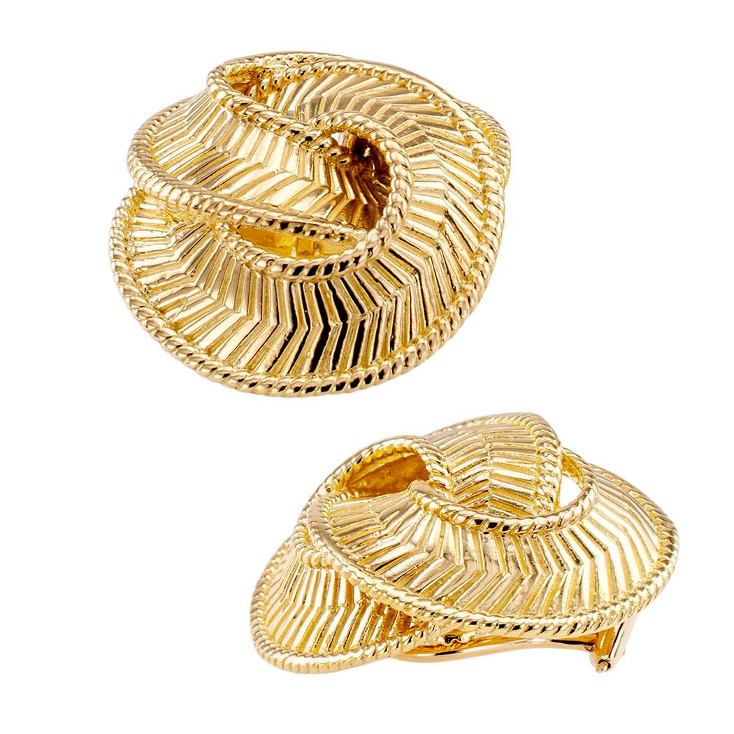 Estate gold clip on earrings circa 1970. The matching designs comprise encircling and entwined gold ribbons decorated with a herringbone pattern, crafted in 18-karat yellow gold with contrasting matt and shiny finishes, omega clip backs. Very