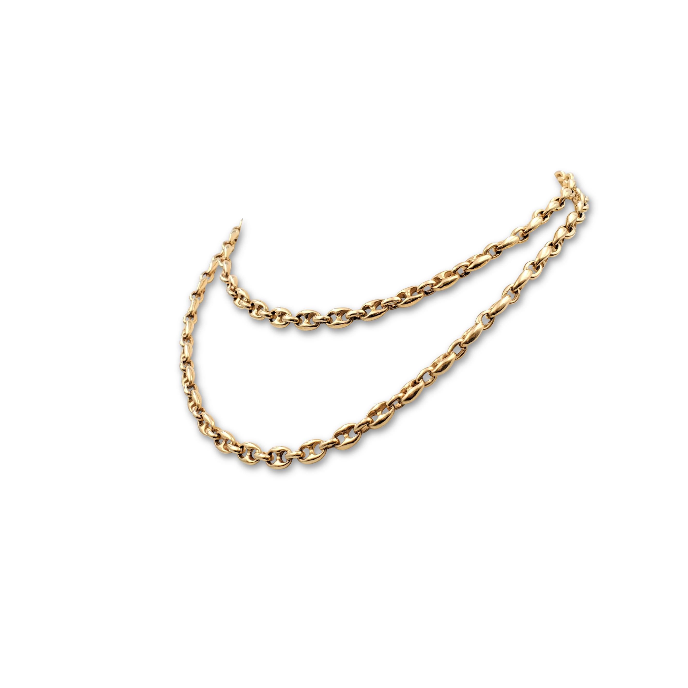 A wearable chain necklace crafted in 14 karat yellow gold comprised of small anchor links alternating with oval-shaped connectors. The chain is long enough to slip overhead, as it has no clasp. The necklace measures 34 inches in length. Not