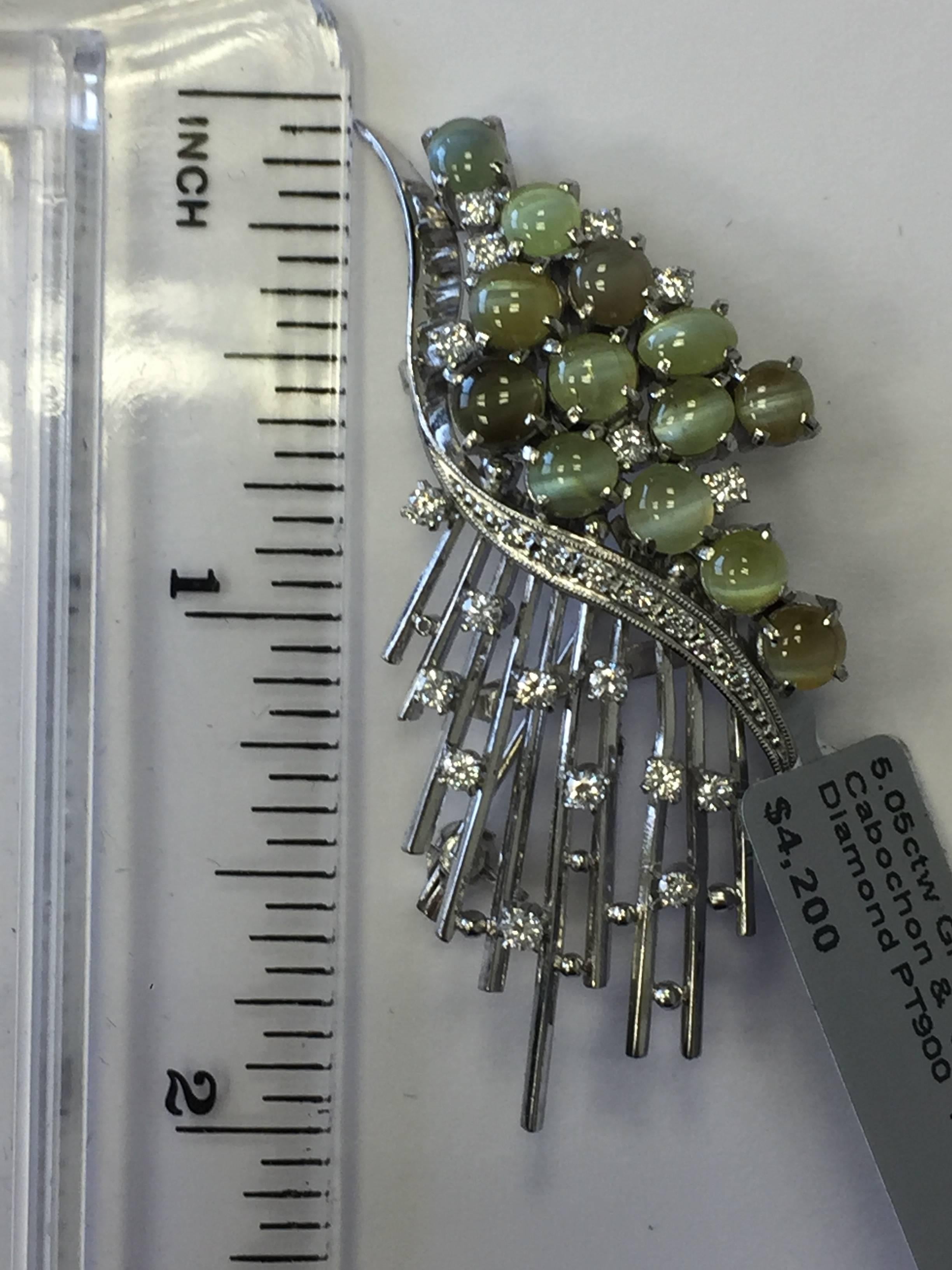 5.05 carats of gorgeous green chrysoberyl cabochons and 0.40 carats of white diamonds in this platinum estate brooch.  A perfect addition to any jewelry collection!