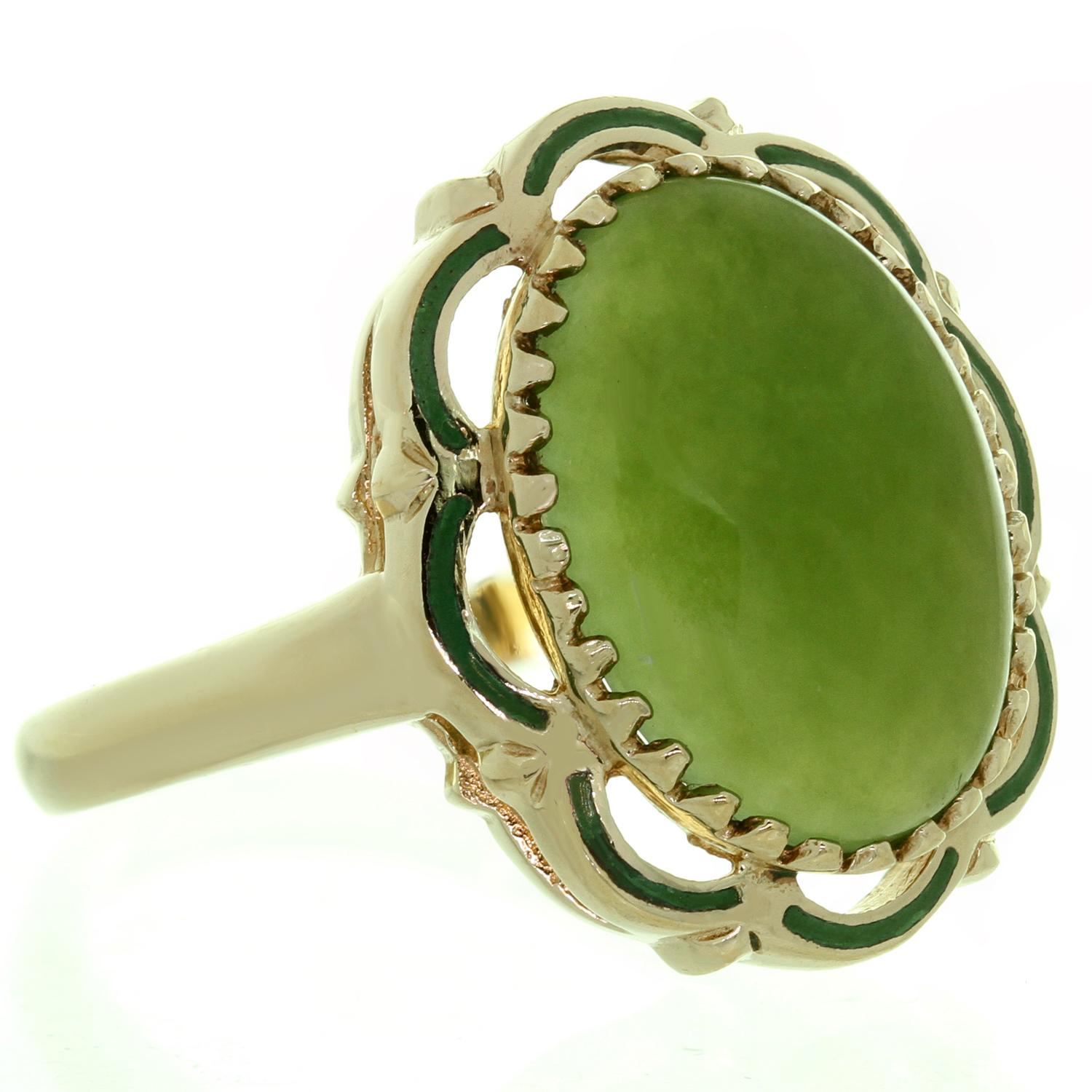 This classic estate collection ring is crafted in 10k yellow gold and is set with a cabochon green jade stone surrounded with a decorative green enamel border. The enamel has a small pinpoint deficiency. Made in United States circa 1960s.