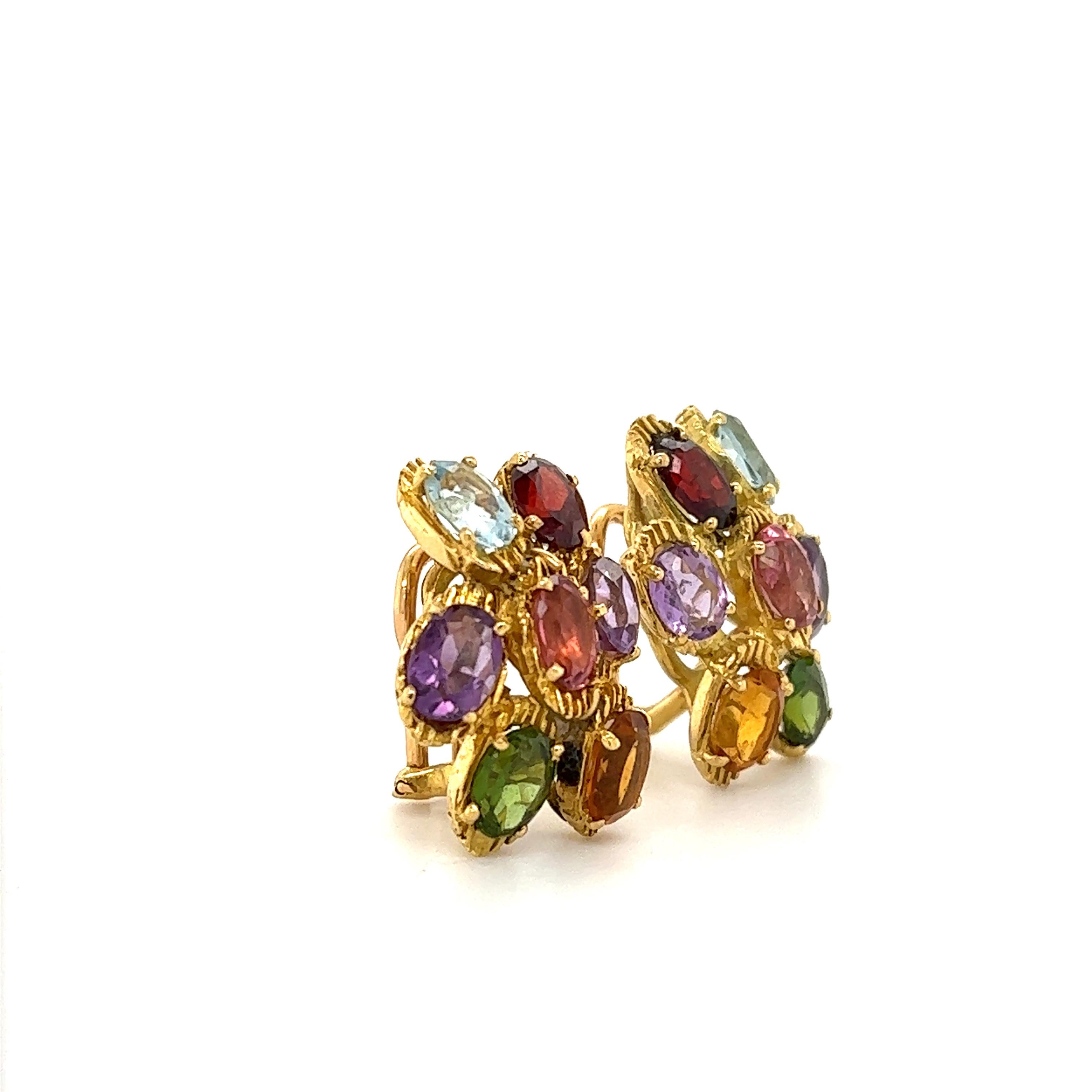 Beautiful pair of earrings crafted by famed designer H. Stern. The pair is set with multi colored gemstones that pop with color and contrast perfectly with 18k yellow gold.  The earrings are set with 14 oval shaped gemstones showing vibrant colors. 