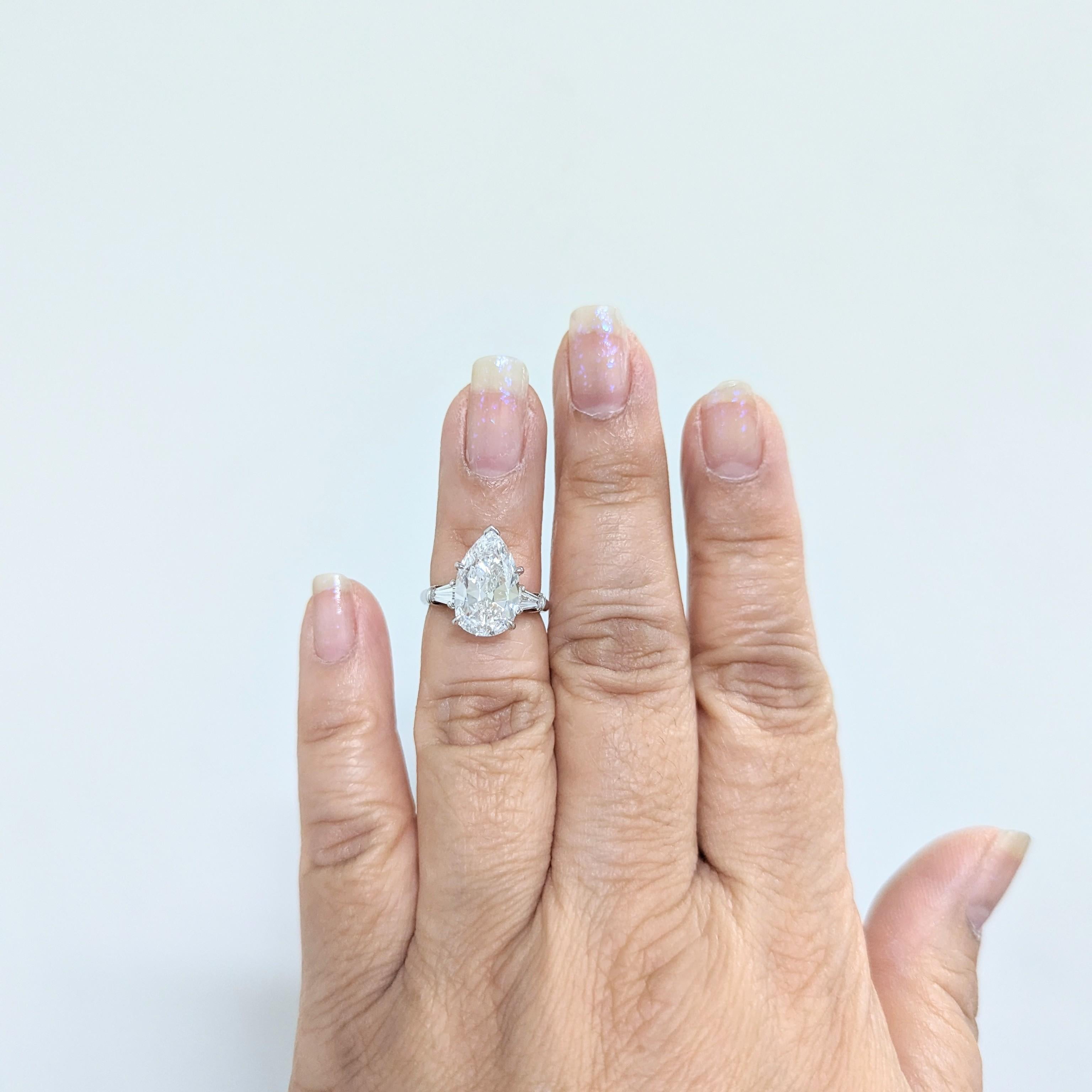 Absolutely gorgeous estate Harry Winston three stone ring featuring a 3.60 ct. white diamond pear shape D VVS1 with 0.34 ct. good quality, white, and bright diamond baguettes on either side.  Handmade in platinum.  Ring size 5.  GIA certificate