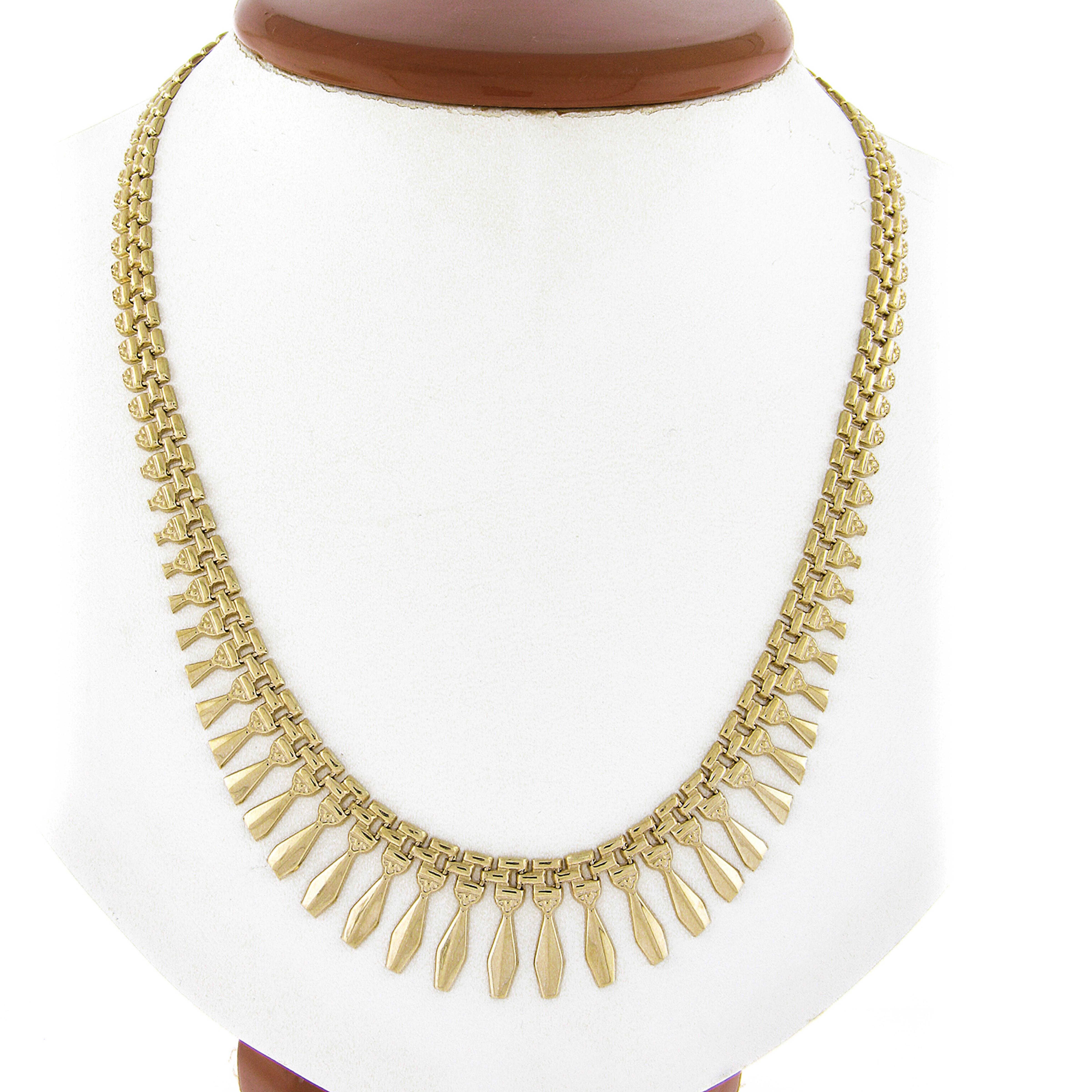 Here we have a Italian fancy fringe collar link chain necklace that is 18 inches in total length. The chain is solid 14k yellow gold with a sturdy box clasp. The center section features a graduated geometric dangles. This interesting and