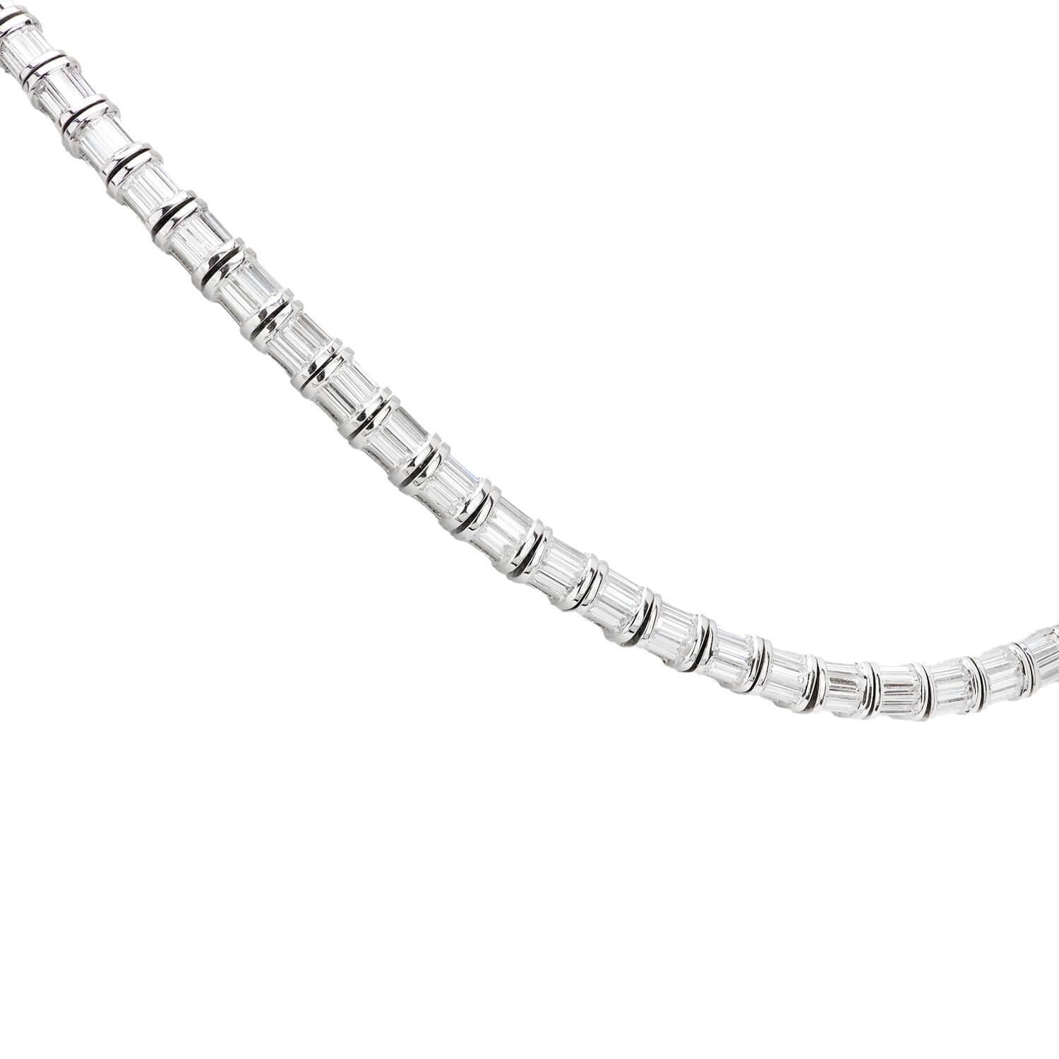 Un exquis collier de diamants riviera ! Réalisé en or blanc 18k, ce collier accrocheur est composé de 77 diamants taille émeraude. Les diamants sont sertis dans des montures simples et élégantes à deux branches et pèsent environ 11,5 carats. Les