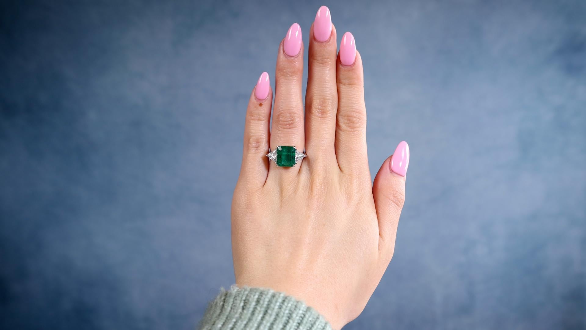 One Estate Italian IGN 4.40 Carat Emerald Diamond 18k White Gold Ring. Featuring one emerald of 4.40 carats, accompanied by IGN certificate #34135. Accented by two trillion cut diamonds with a total weight of approximately 1.00 carat, graded