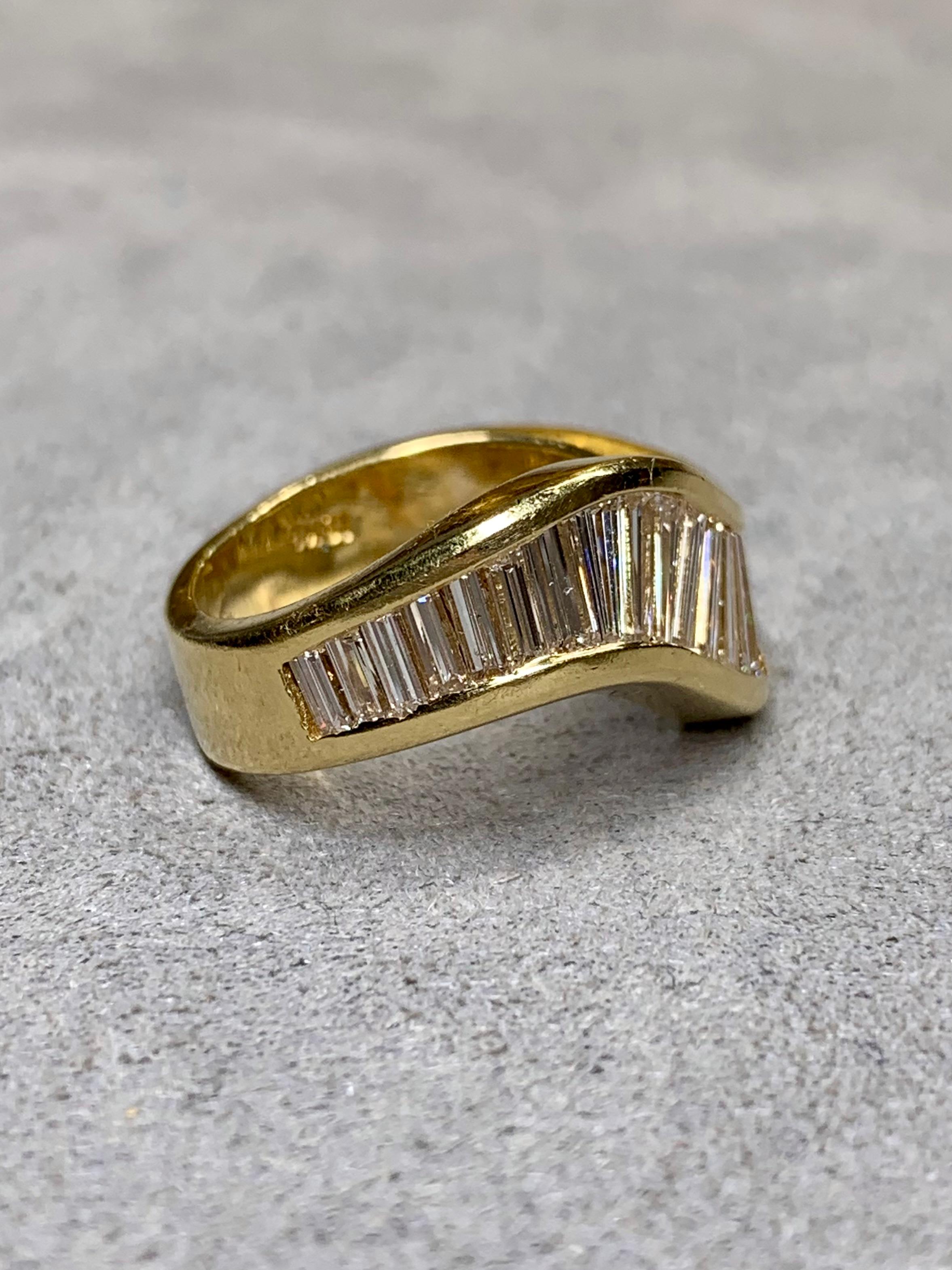 
A gorgeous band by famous New York jewelry house, JB Star ( Jewels by Star). It is done in 18K yellow, gold, and channel set in a stylized wave pattern with approximately 2.70ctw in graduating sized straight and tapered, baguette diamonds ranging
