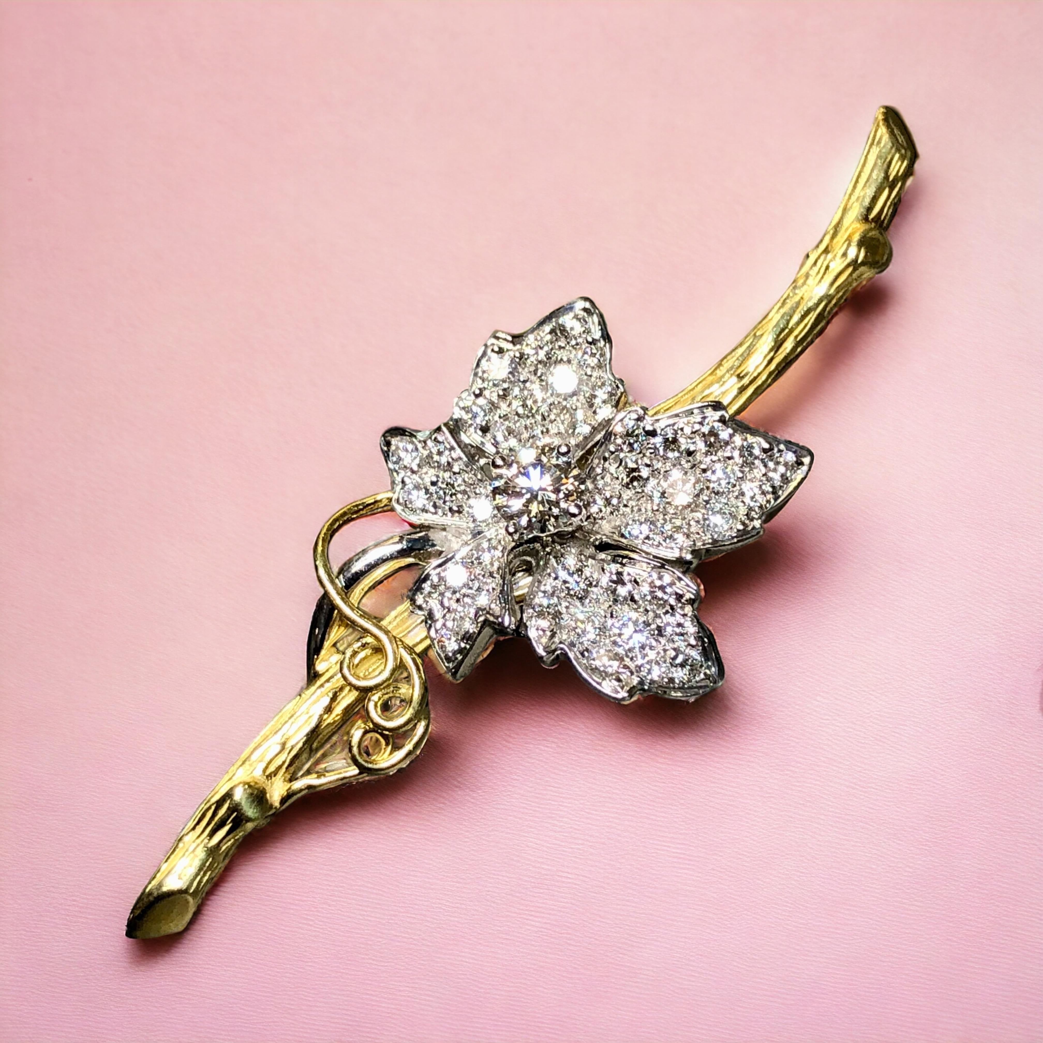 
A two tone flower brooch done in 18K yellow and white gold by renowned New York designer, KWIAT. It has a lovely detailed textured finish and set with approximately 1.45cttw in F-G color Vs1+ clarity round diamonds. This piece has been hallmarked