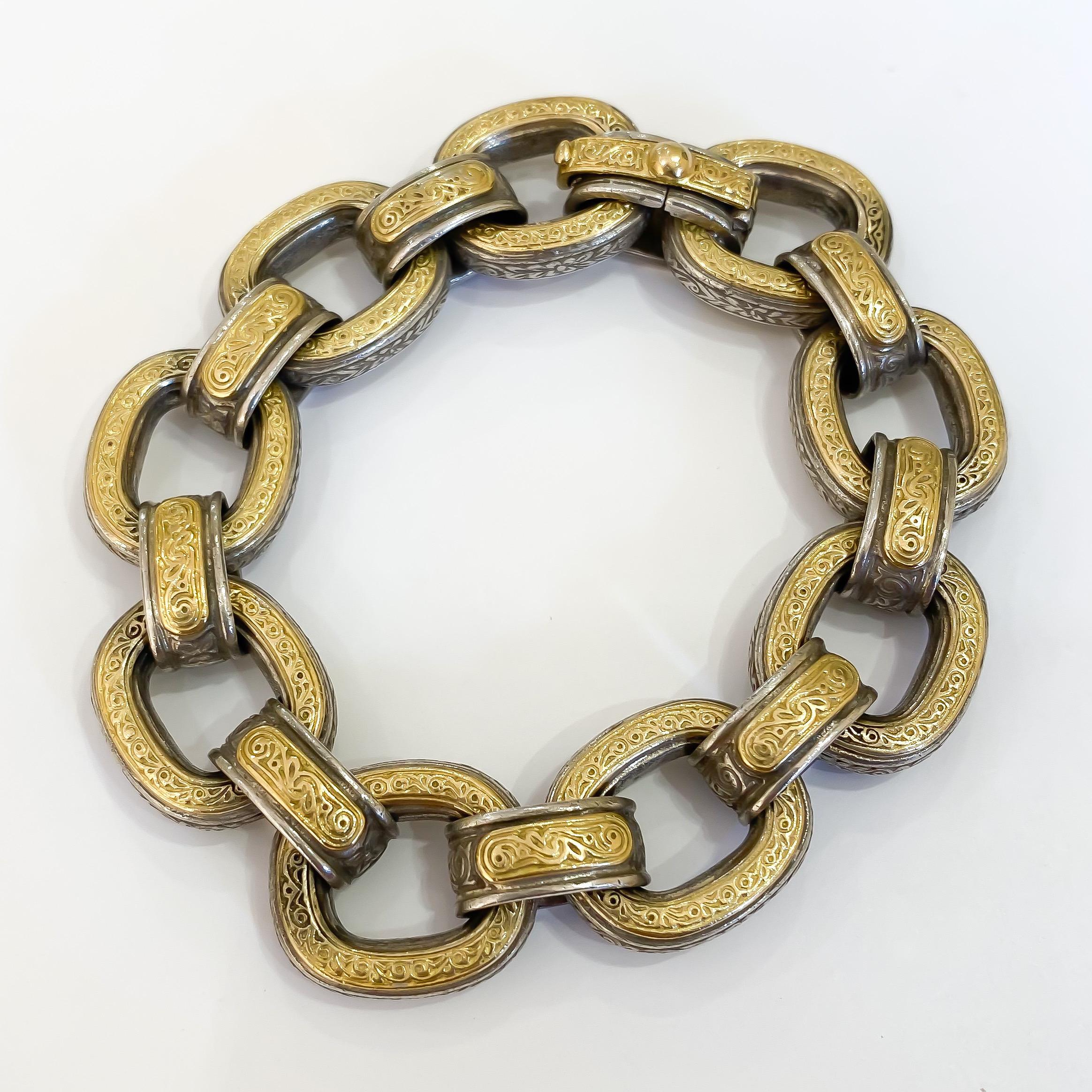 Estate lady's reversible engraved carved open link bracelet designed by Konstantino in sterling silver and 18 karat yellow gold. The open hollow links measure 16mm with an oval fold over clasp. Both sides and profile are elegantly engraved to make