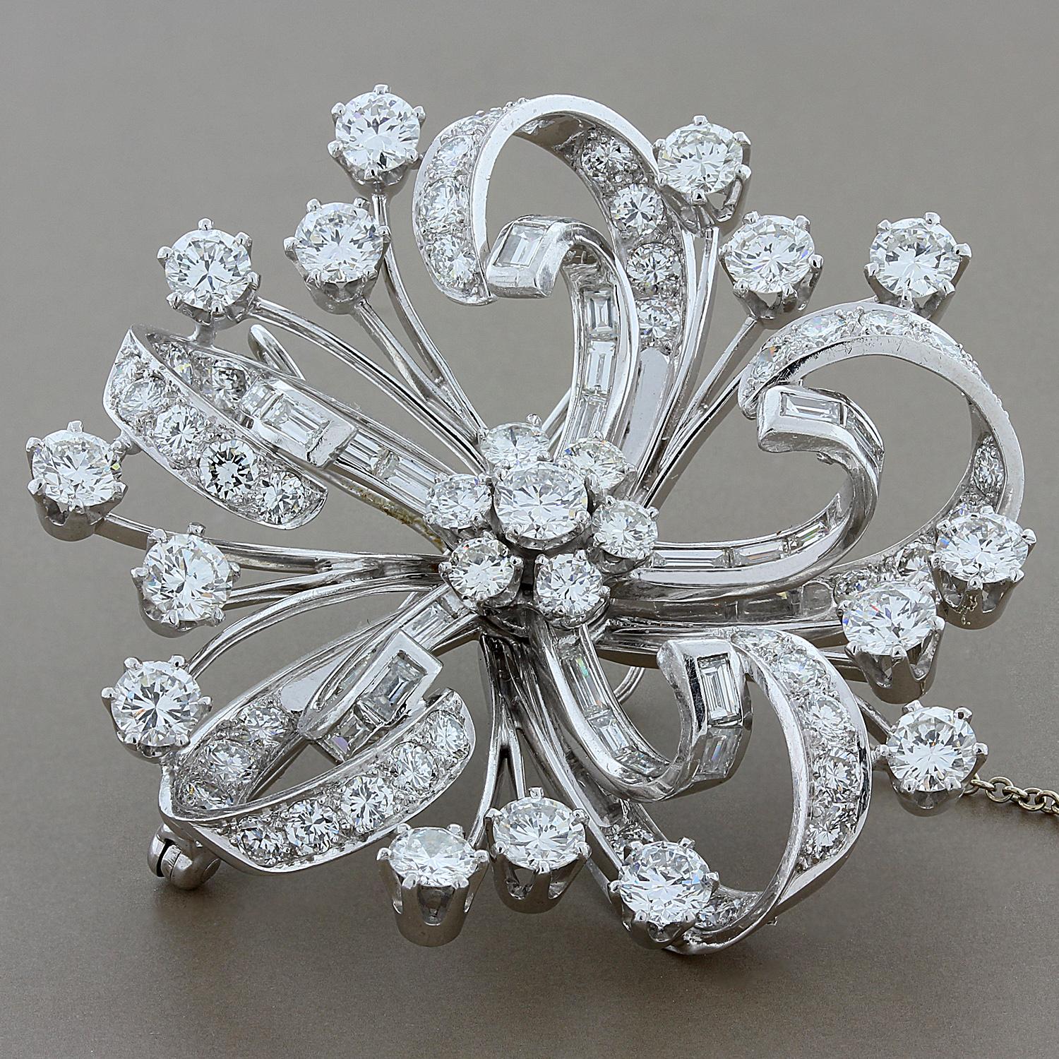 The large flower brooch features 12.80 carats of full cut and baguette diamonds. Set in platinum and completed by a pin stem and catch, along with a safety chain.  This spectacular brooch doubles as a pendant.

Measures 2 inches in diameter
Safety