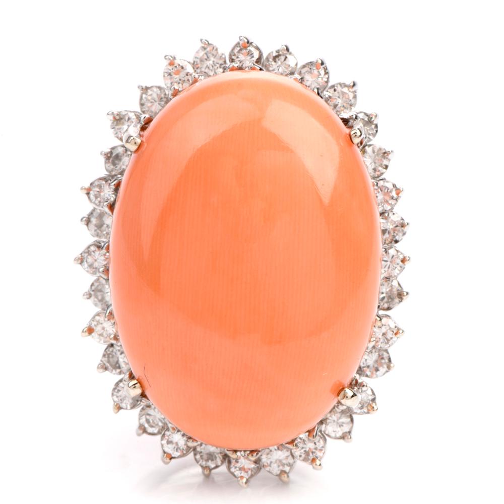 The beautiful cocktail ring features a very large soft pink oval shaped

cabachon cut natural Coral measuring appx. 18.99 x 26.1 x 11.15mm High.

Offering dimension to the outer rim of this ring are 32 diamonds

alternating on 2 eneven rows.