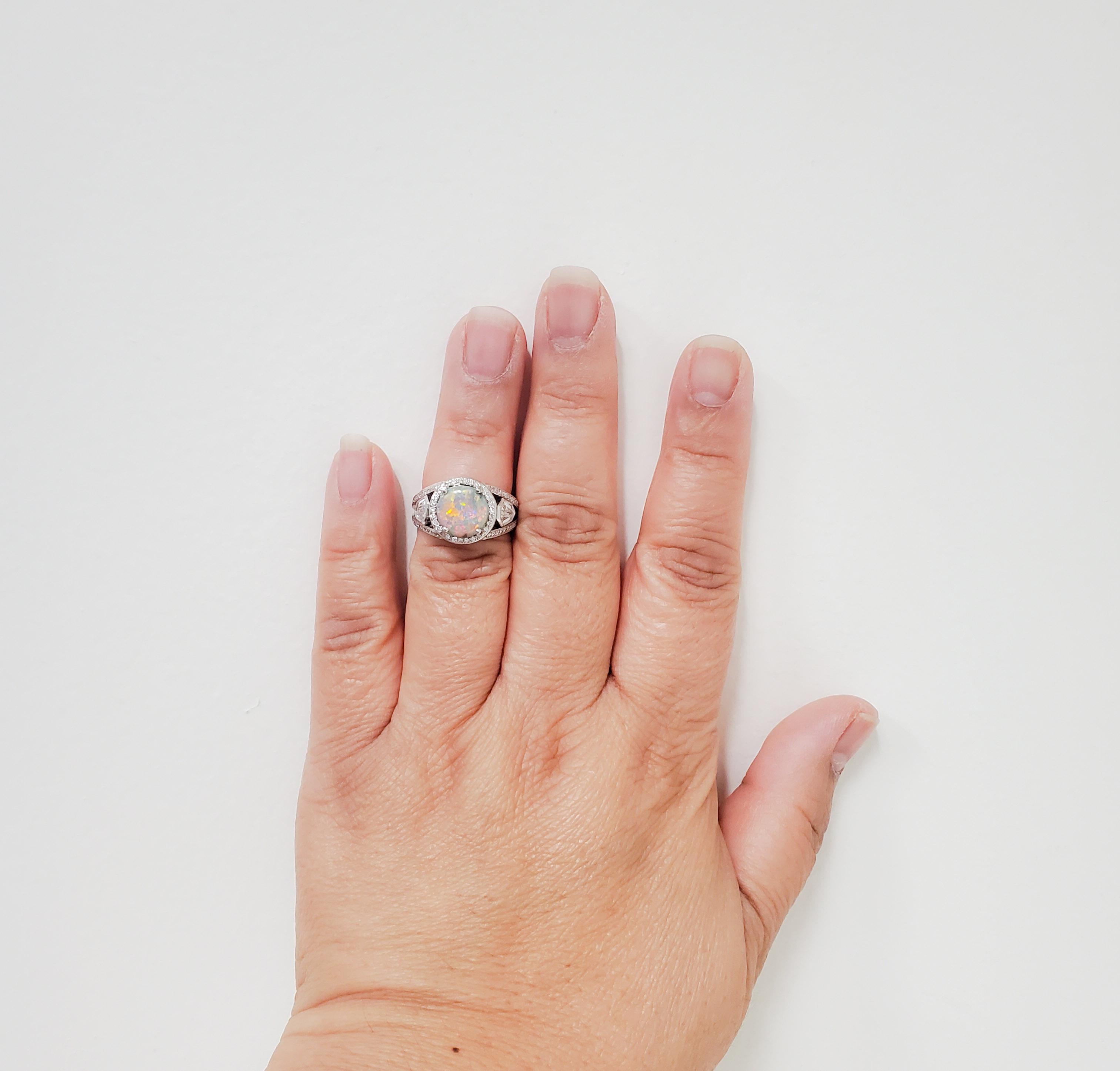 Beautiful estate Lugano ring featuring a 2.25 ct. opal round and 2.50 ct. of good quality white diamond kite shapes and rounds.  Ring size 5.75.  Handmade platinum mounting.