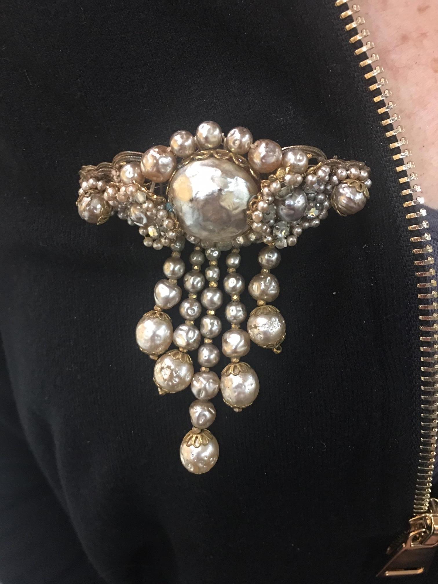 Exquisite Antique Miriam Haskell Dangle Brooch centering a Large Faux Pearl, surrounded by clusters of embroidered seed pearls, rhinestones and smaller Faux Pearls terminating in an oval design, suspending 5 strands of dangling graduated Faux