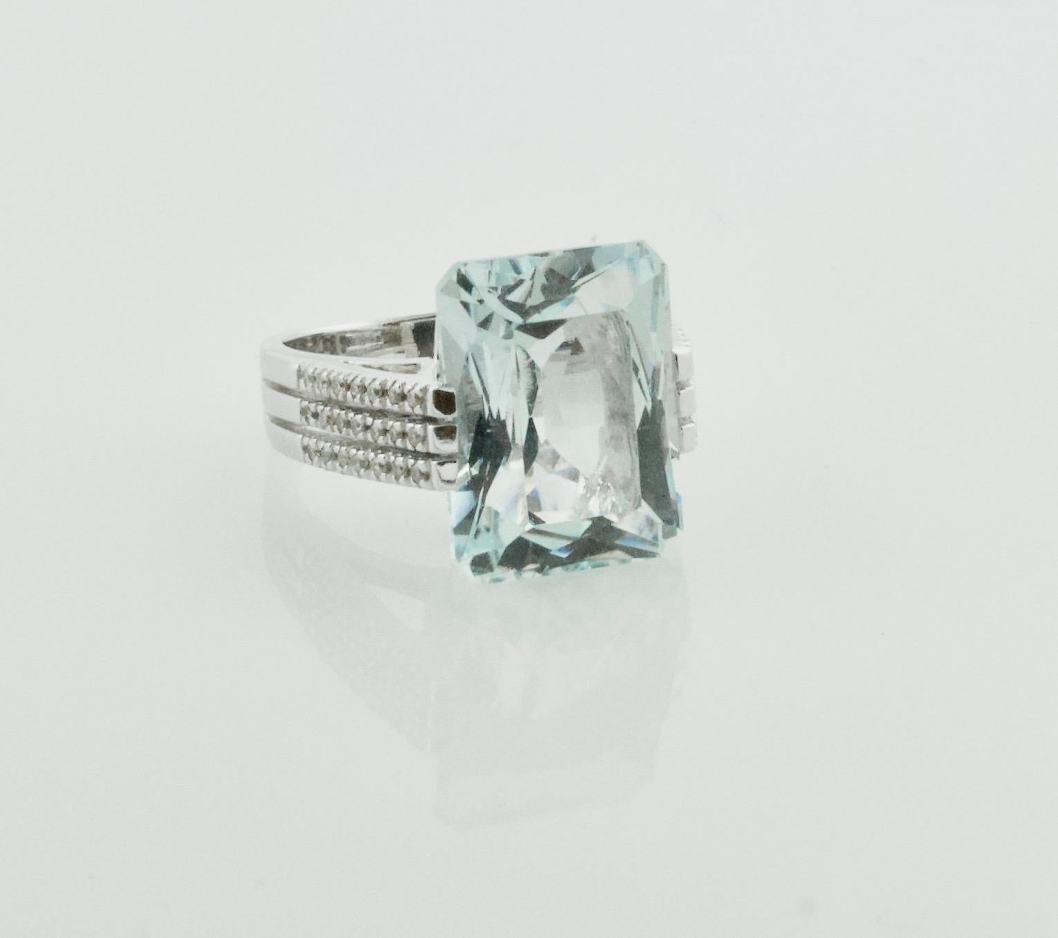 Introducing the Estate Modernistic Aquamarine and Diamond Ring in White Gold, a true work of art that will take your breath away. This stunning ring features a large emerald-cut aquamarine gemstone weighing approximately 12.00 carats, perfectly set