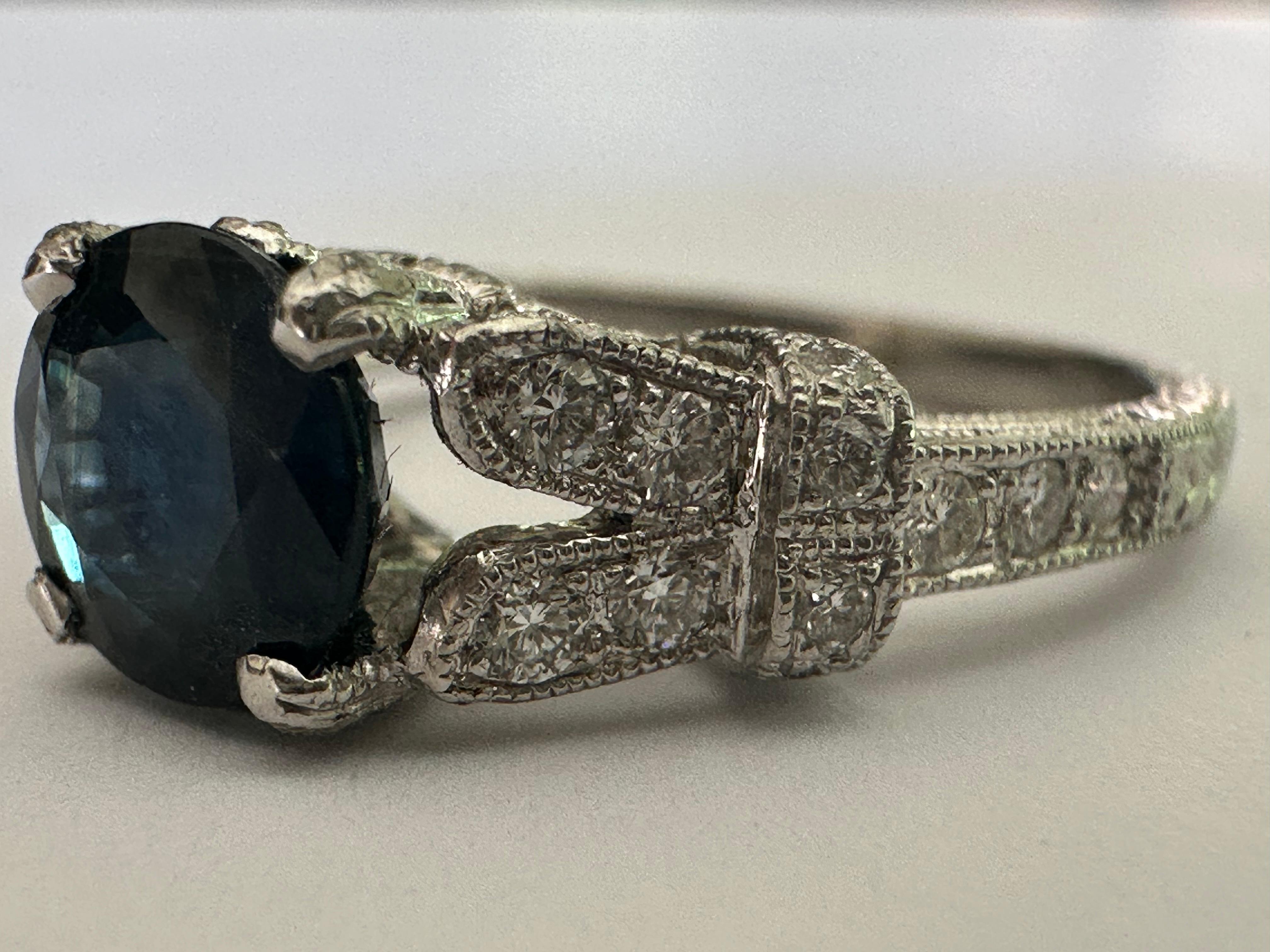 A round natural blue sapphire measuring approximately 1.38 carats centers this exquisite estate engagement ring embellished with thirty round diamonds totaling approximately 0.30 carat. Set in platinum. 
