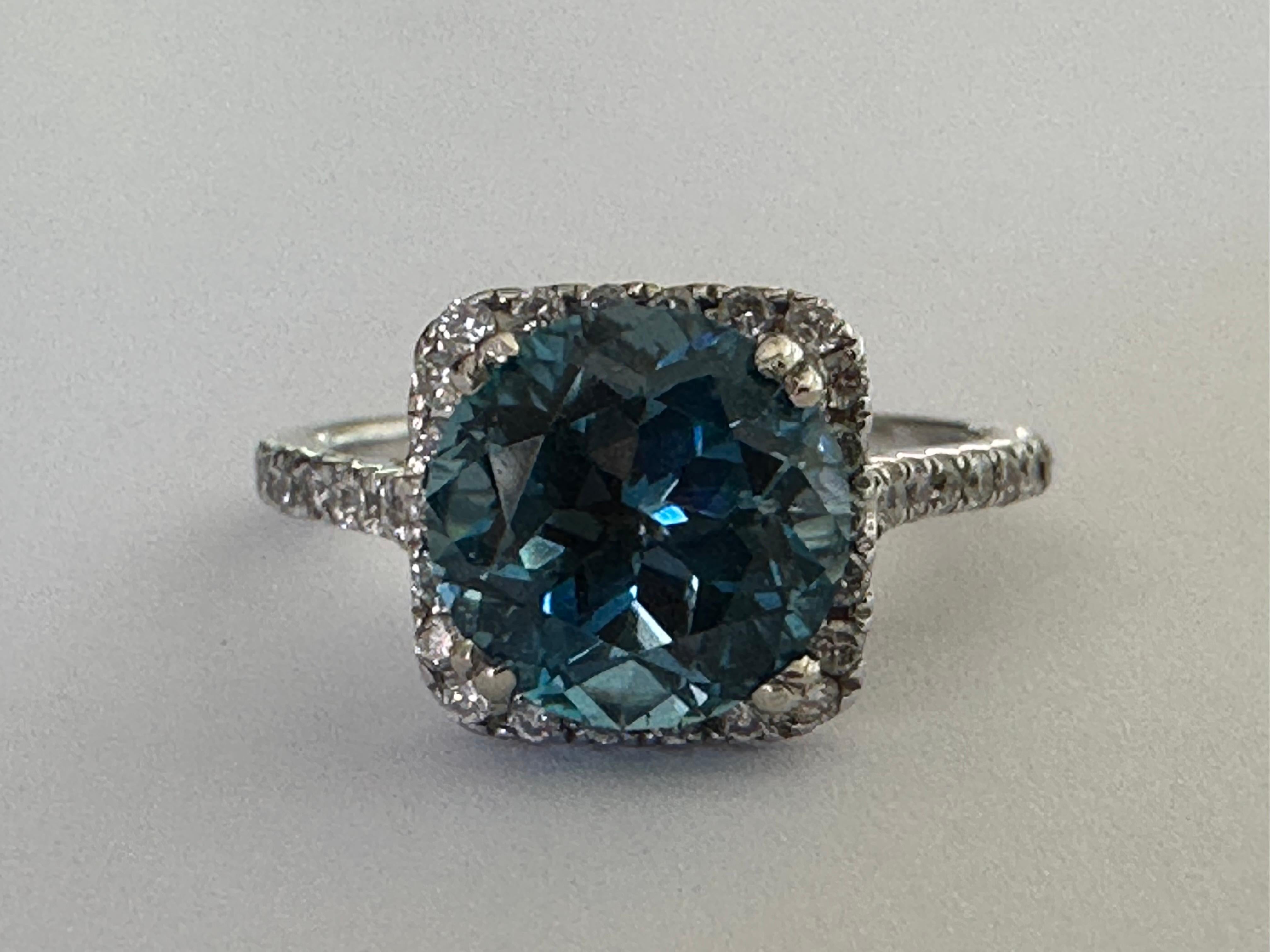 A natural blue round-shaped topaz centers this dazzling ring. The 2.52-carat gem is encircled by a halo of 0.42 carats of sparkling white brilliant-cut diamonds, F color, SI1-2 clarity. Set in 14K white gold. 