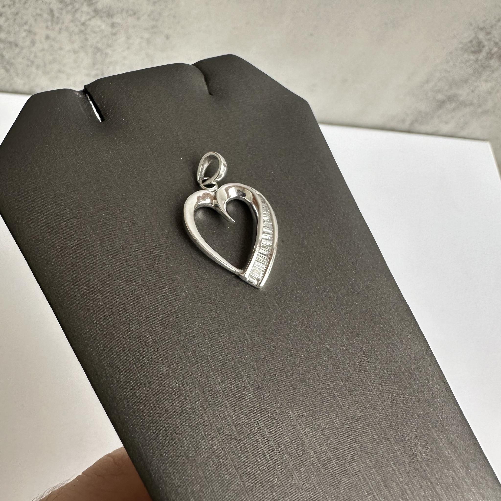 This stunning Estate Natural Diamond Heart Necklace features approximately 0.45ctw of natural GH SI2-I1 baguette cut diamonds, delicately set in a platinum heart-shaped pendant. Weighing 3.5 grams and stamped PT900, this piece showcases the timeless