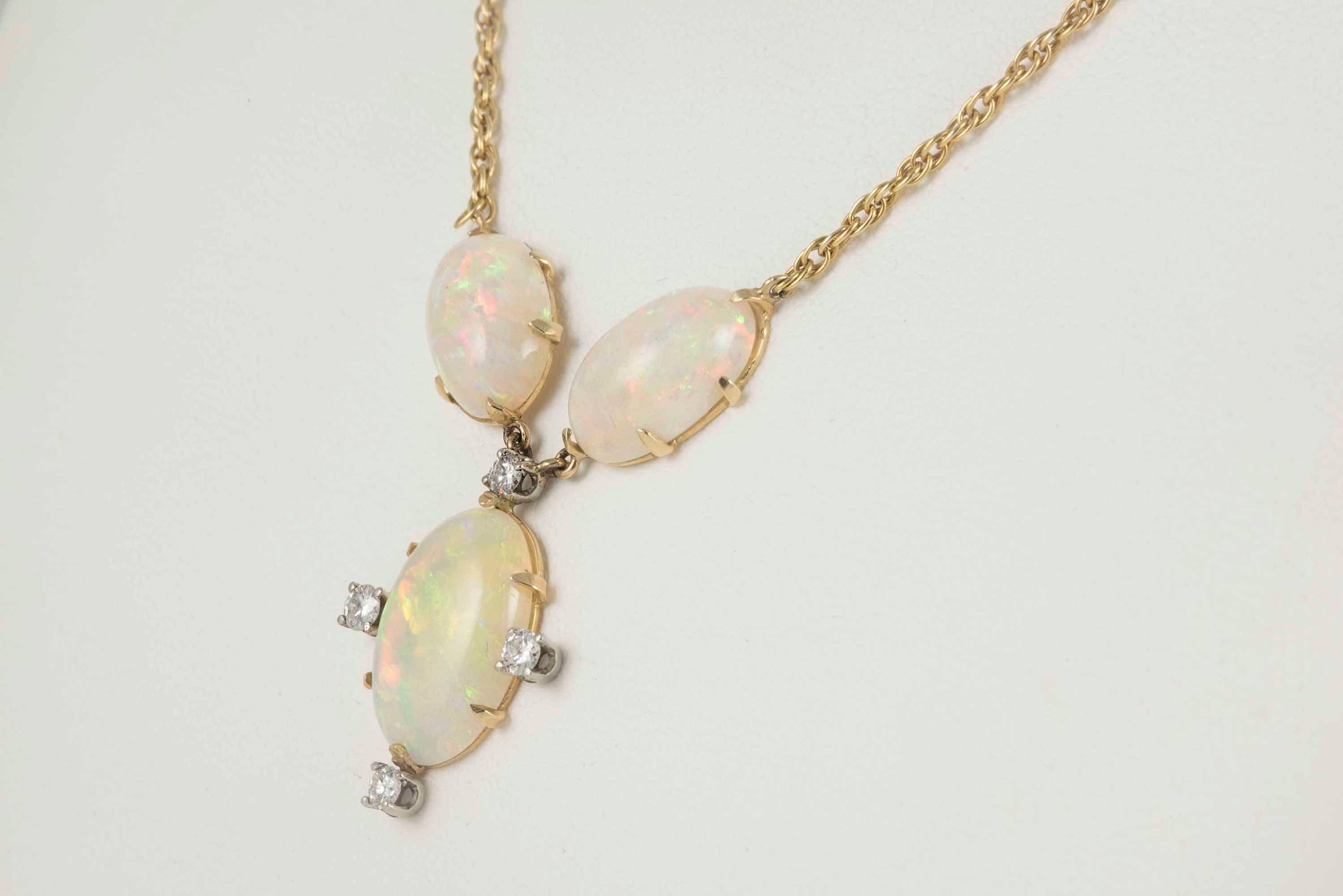 A trio of natural fine oval-shaped cabochon Australian opals -- two measuring 9mm x 5mm, one measuring 12mm x 18mm -- adorn this estate necklace crafted in 14kt yellow gold and embellished with four round diamonds totaling approximately 0.40 carats.