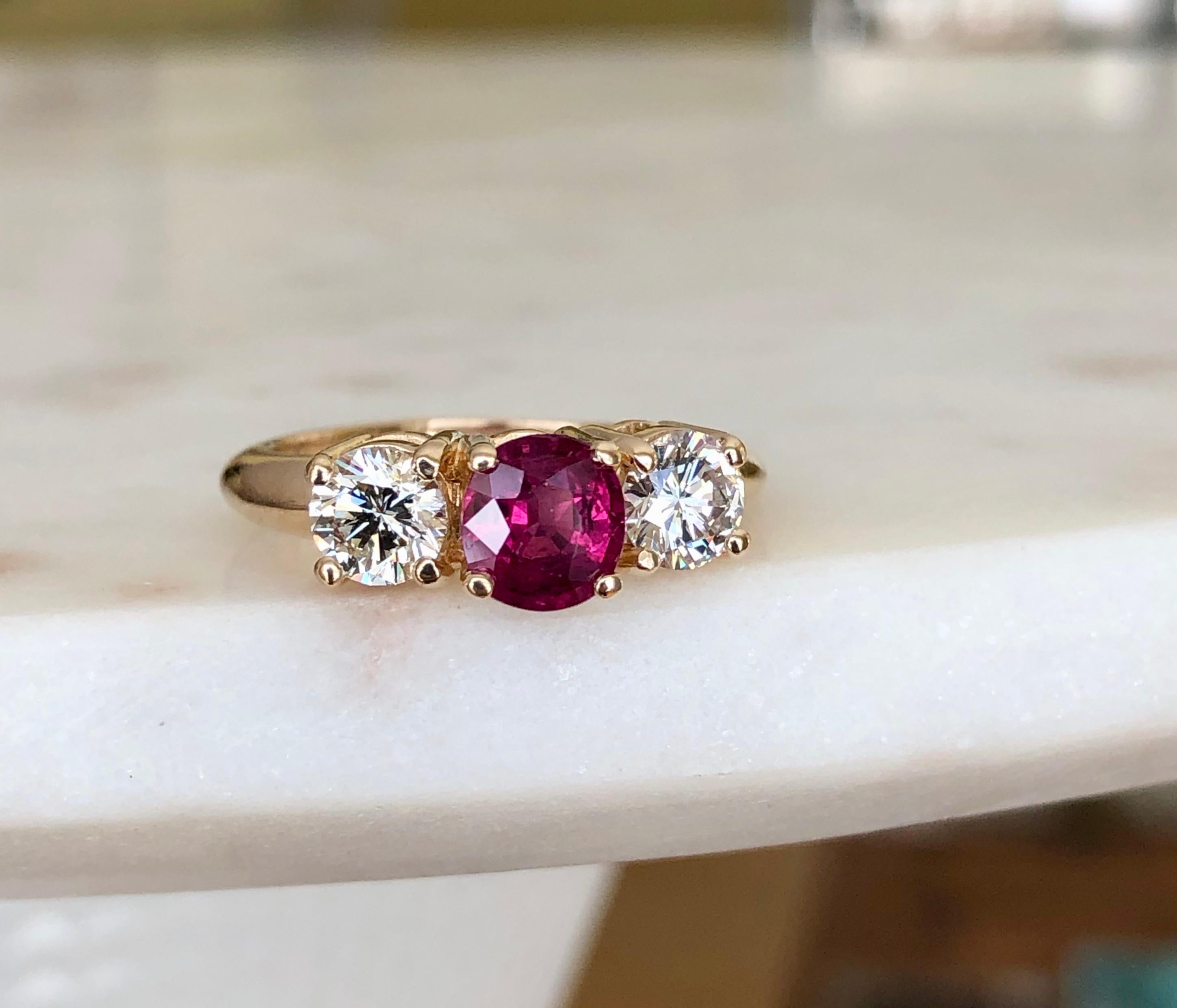 This classic trilogy engagement ring stars a natural deep, rich red ruby weighing Approx. 1.20 carat flanked by a matched pair of brilliant-cut diamonds H-SI1 weighing over 0.90 carat. This elegant ring is crafted in a timeless, traditional style