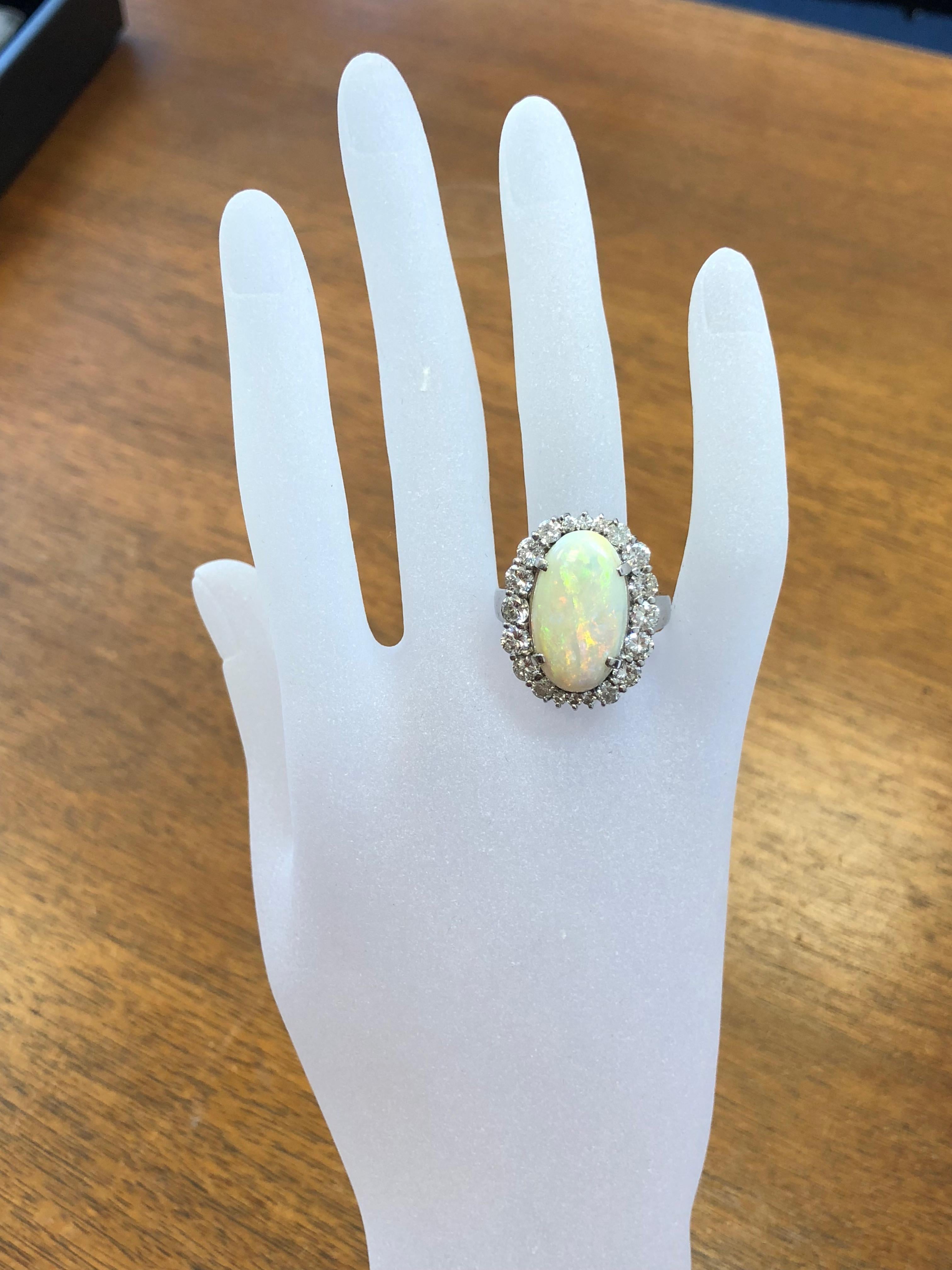 Beautiful 8 carat estate oval opal surrounded by 2.36 carats of white diamonds.  The opal has stunning hues of green, orange, and gold.  The white diamonds are good quality and lustrous.  The ring is a size 9.25 in platinum.  This is the perfect