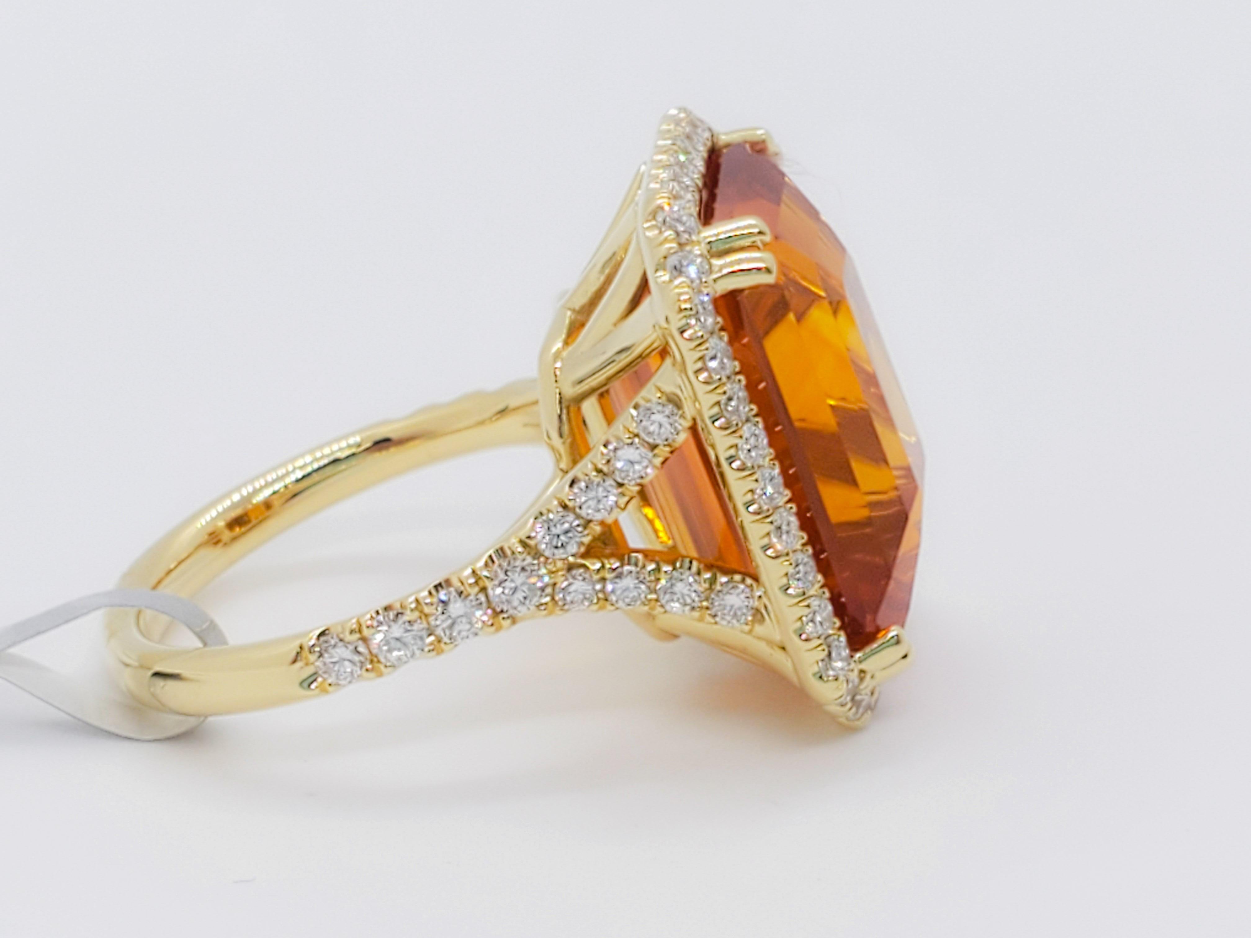 Stunning bright orange sapphire octagon that weighs 20.10 cts.  The color of orange on this stone is incredible and the shape is hard to find.  It has 0.93 ct of good quality, white, and bright diamond rounds.  Handmade mounting in 18k yellow gold. 